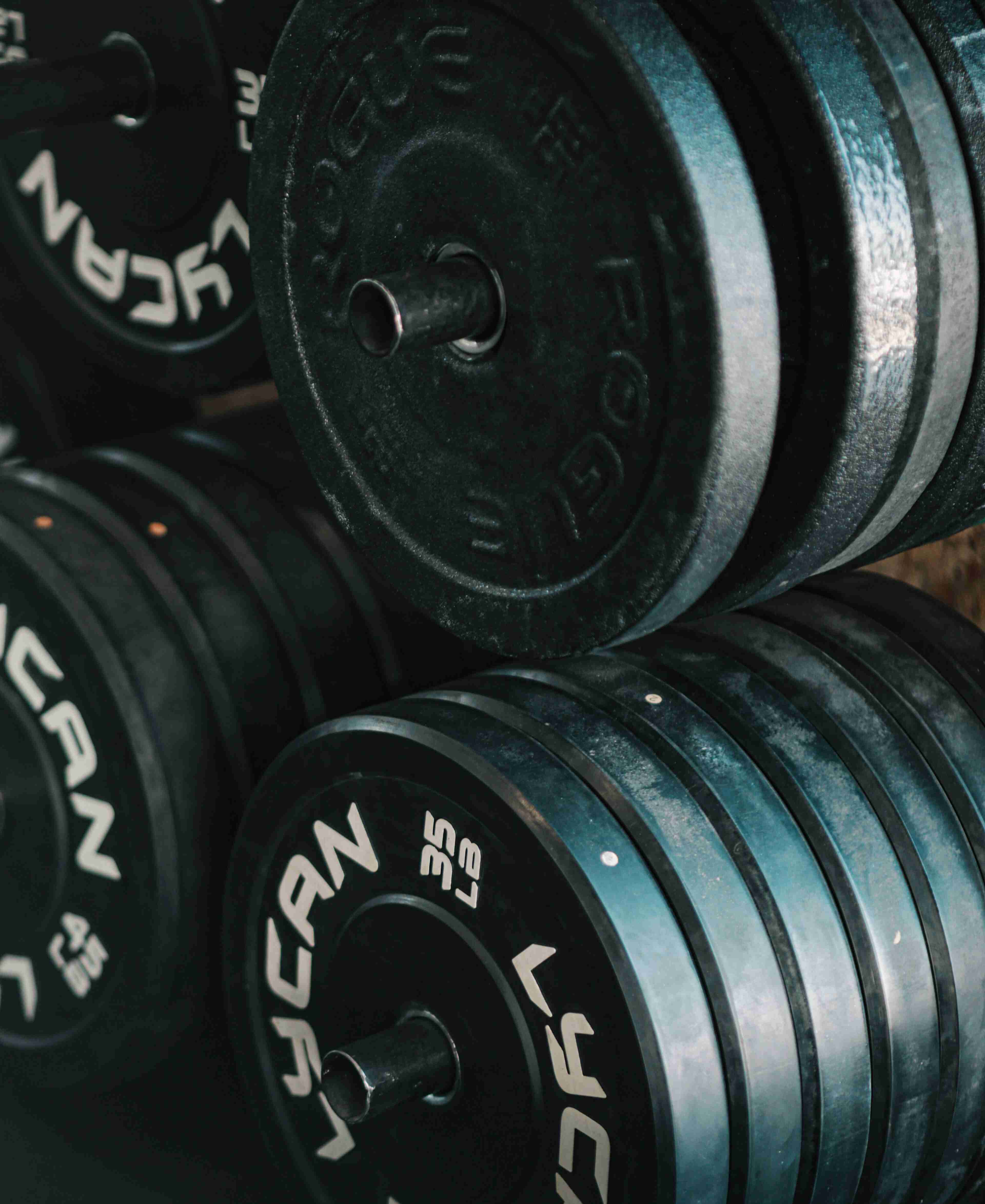 Metal rack of black and grey Olympic-sized weight plates