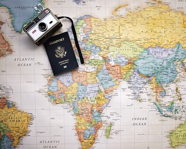 World map for trip planning, with passport and camera on top