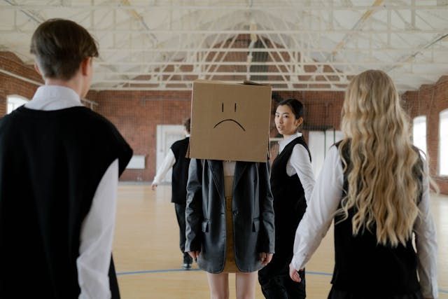 Students bully a peer in the school hallway.