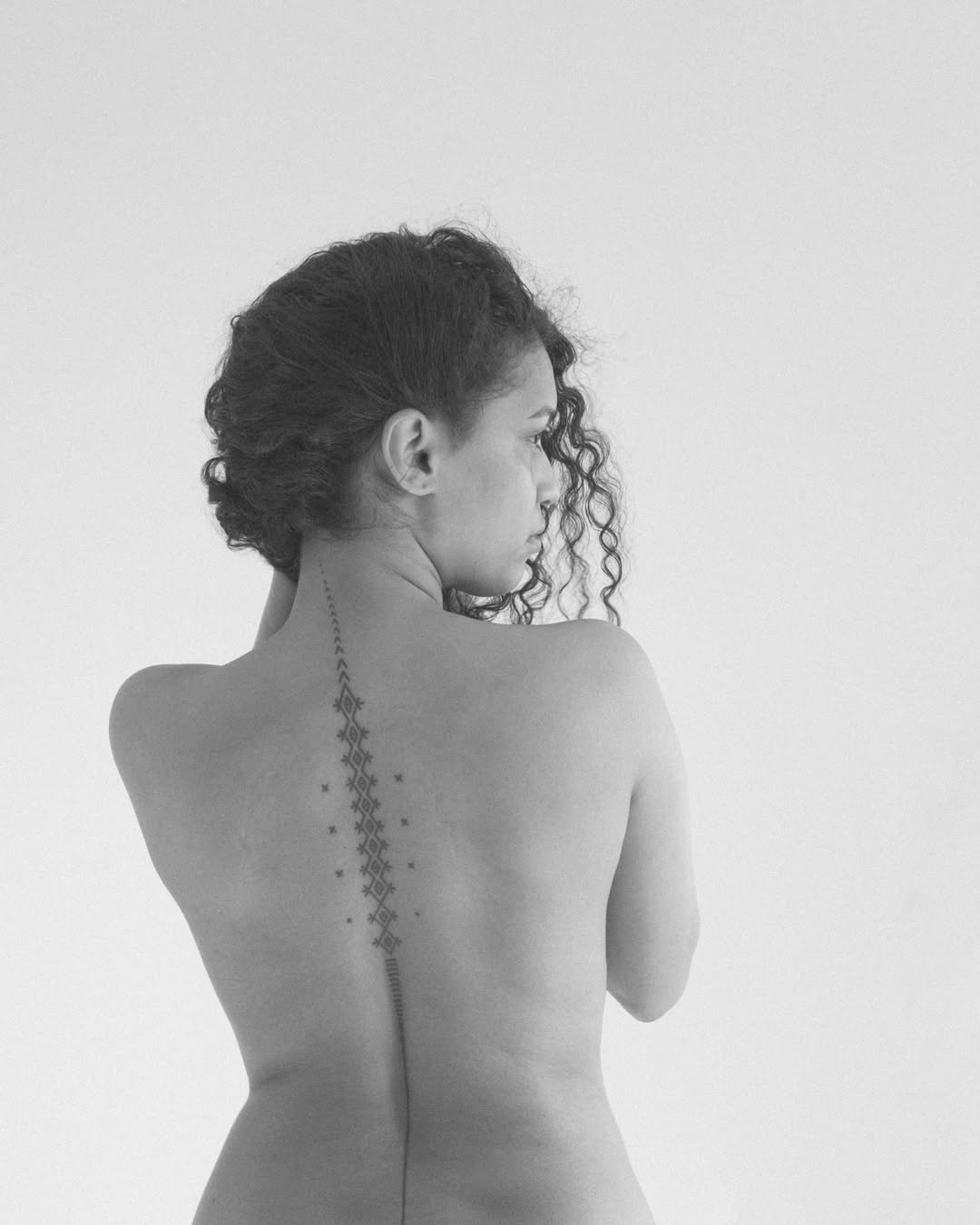 Vertical spine diamond handpoke by Mo Naga