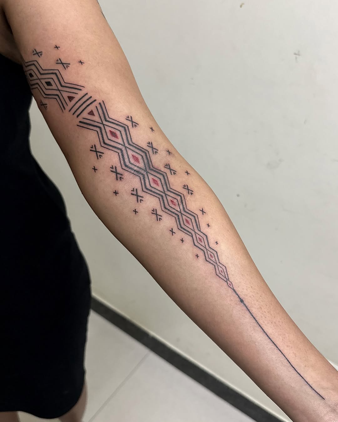 Forearm zigzag tribal handpoke by Mo Naga