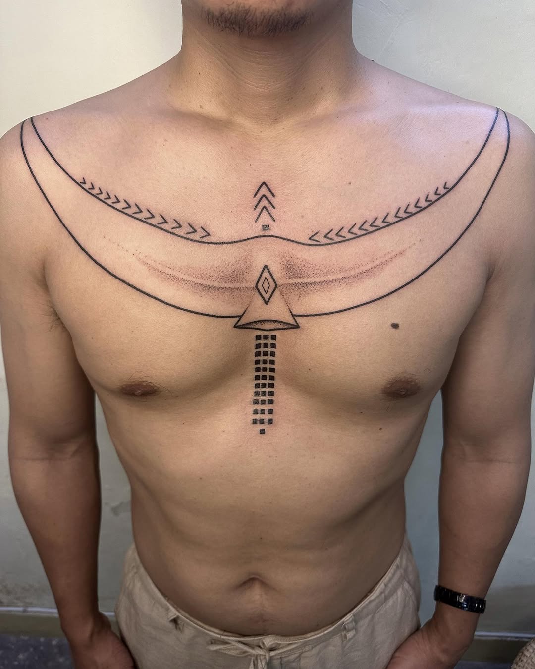 Chest chevron handpoke tattoo by Mo Naga