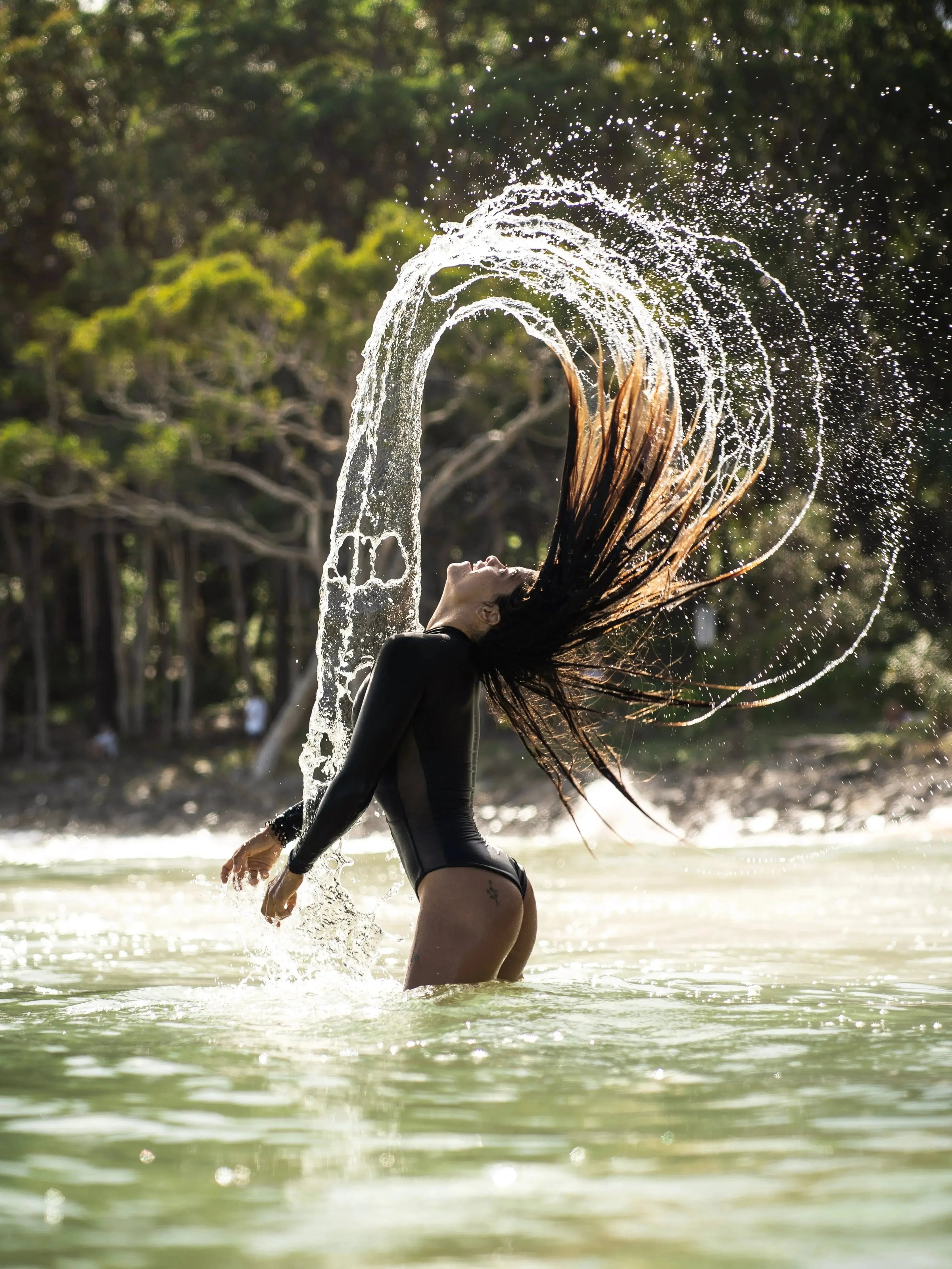 side view of woman wearing a Black Long Sleeve Swimsuit | The Sulawesi Midnight 