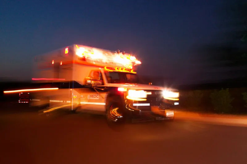 Ambulance with emergency lights on, representing the dedication and 24-7 commitment of EMS professionals