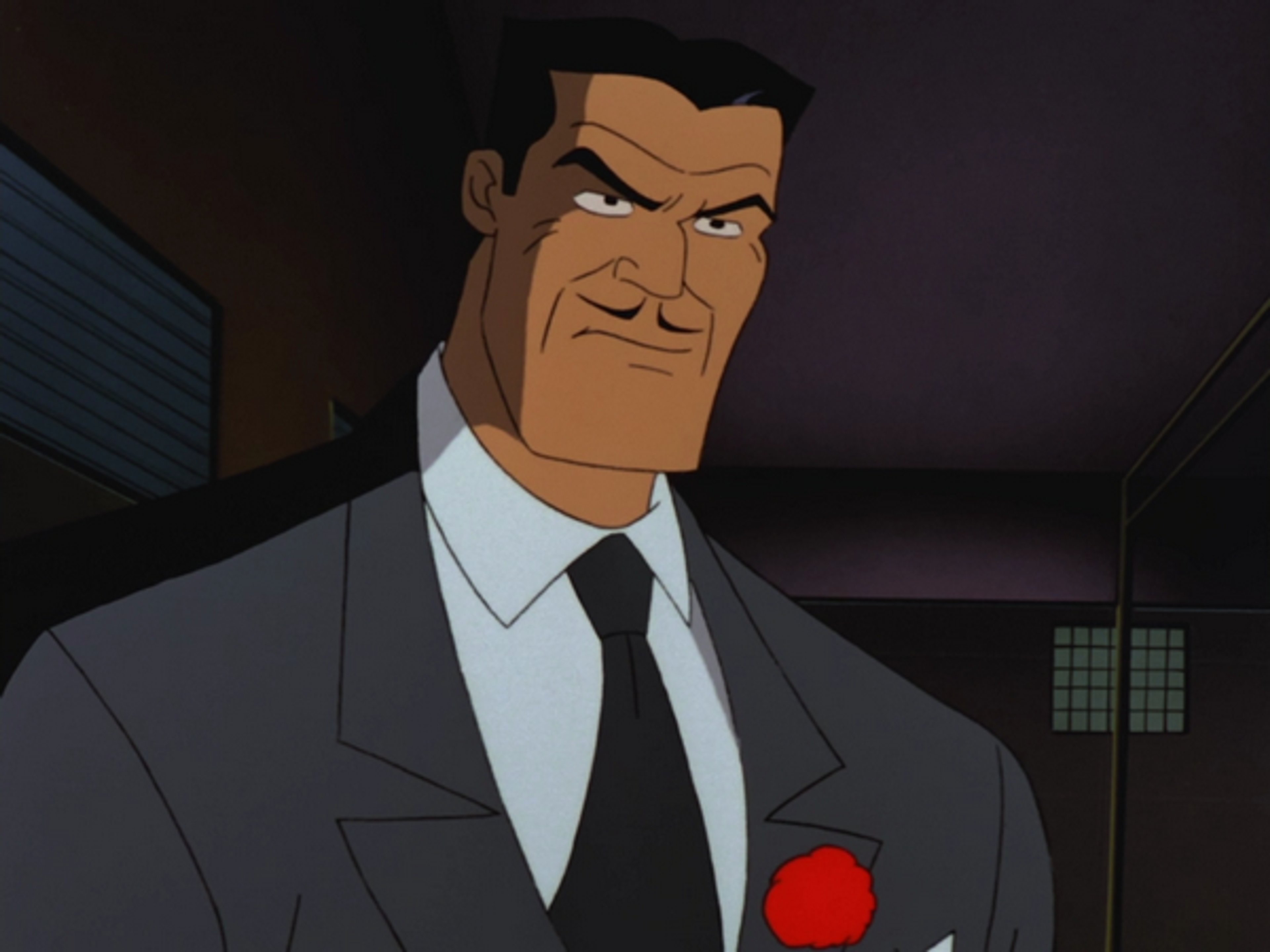 A middle-aged man in a suit and tie with a stern expression