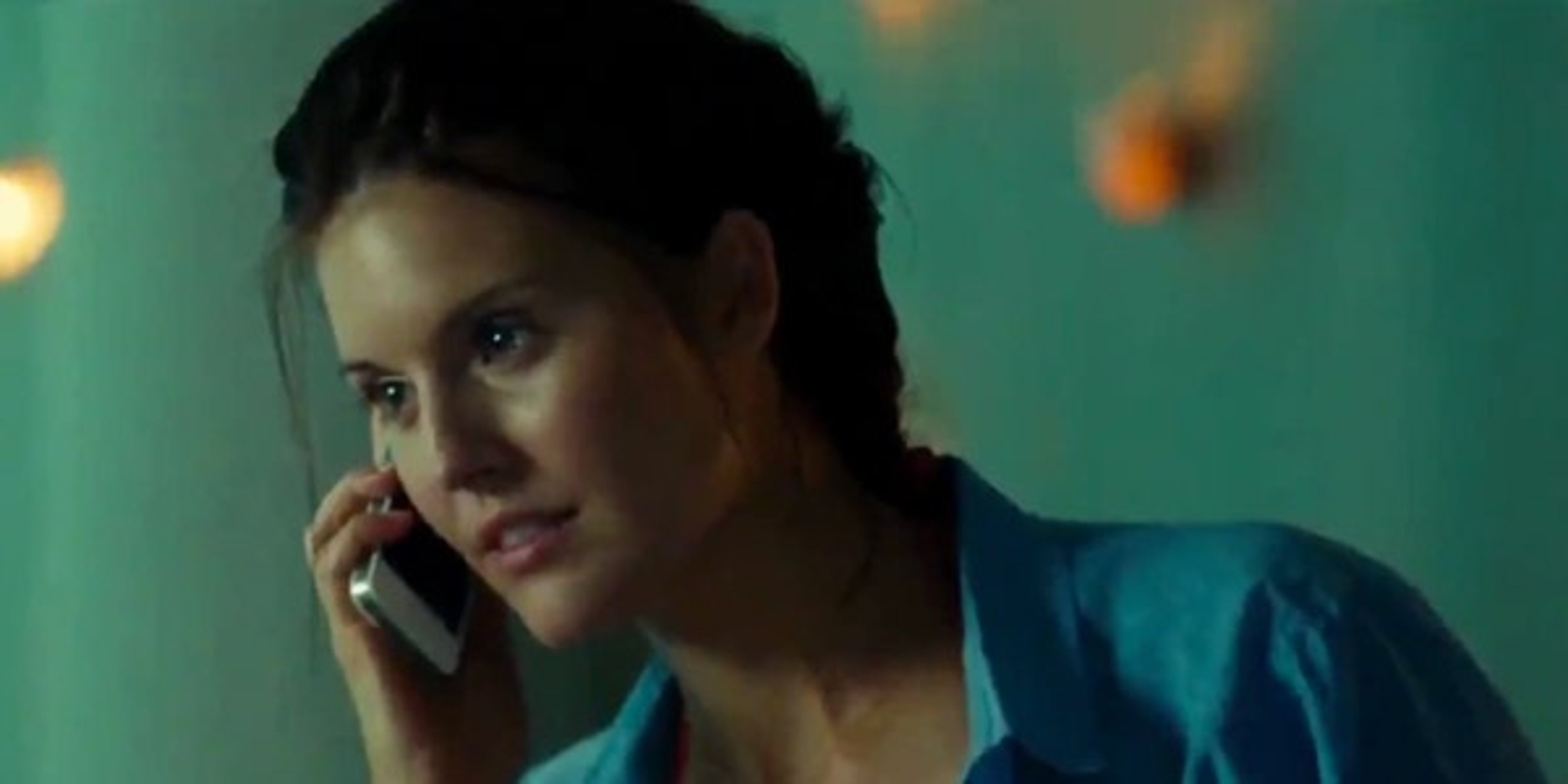 A young woman with dark hair speaking on a phone