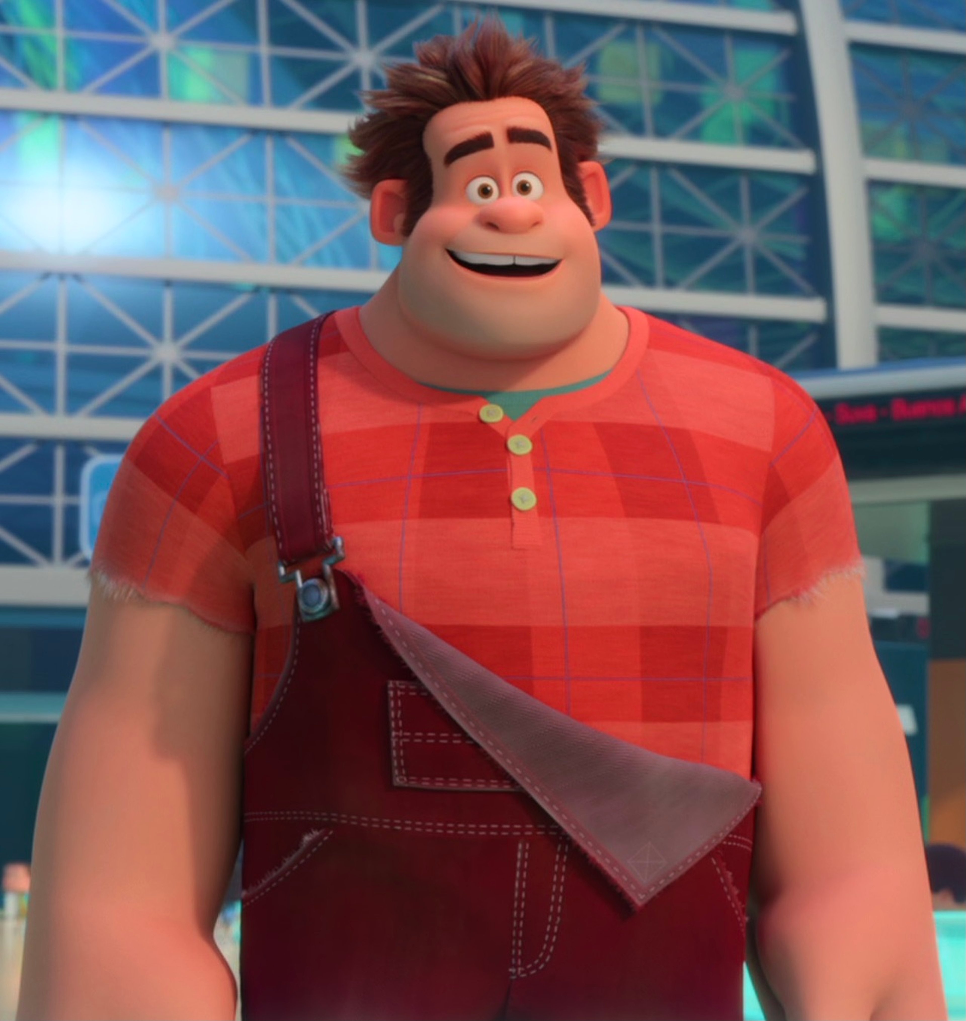 A cartoon character named Wreck-It Ralph, a large muscular man with brown hair and a beard wearing a red plaid shirt and overalls