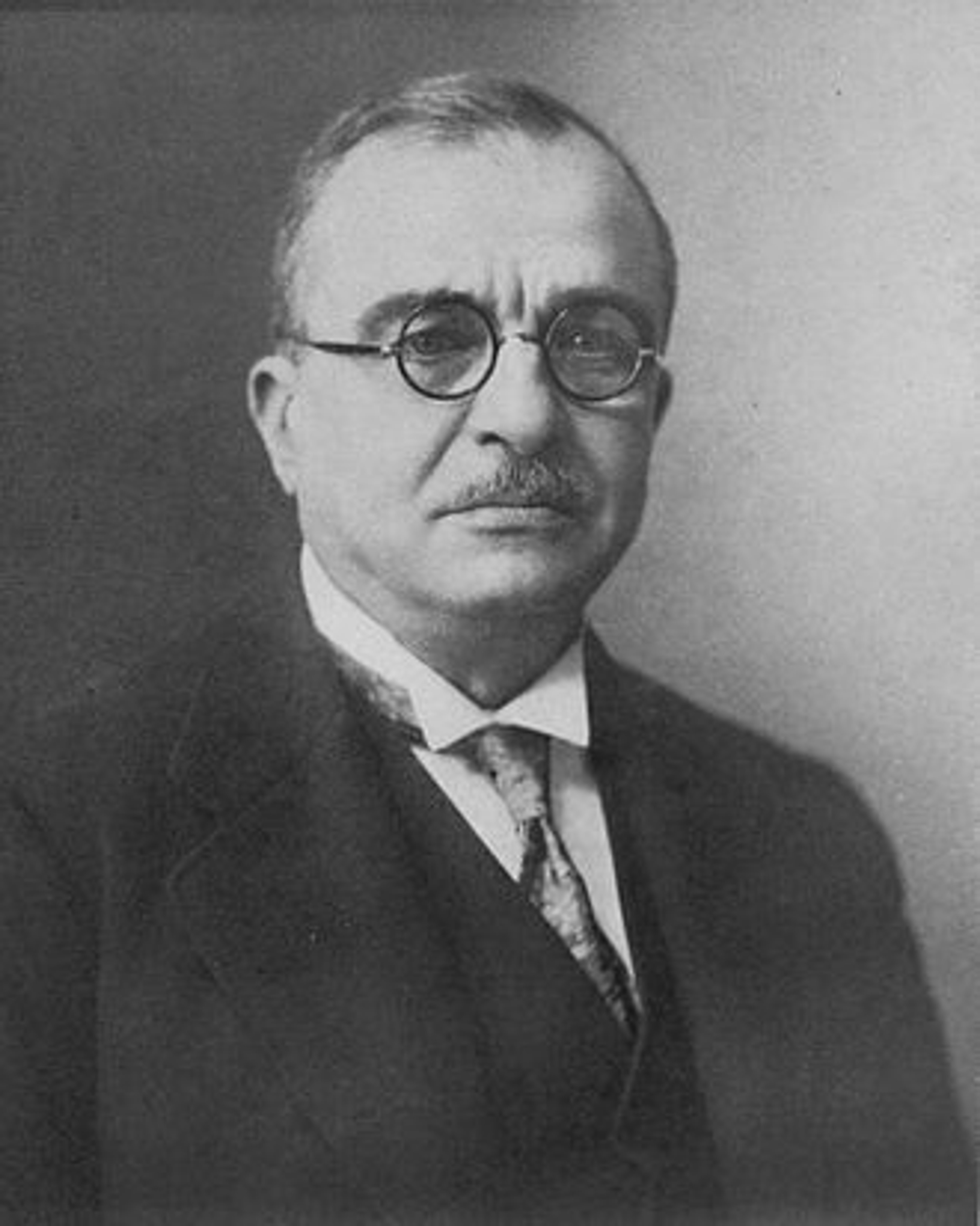 Portrait photograph of a middle-aged man in a suit and tie