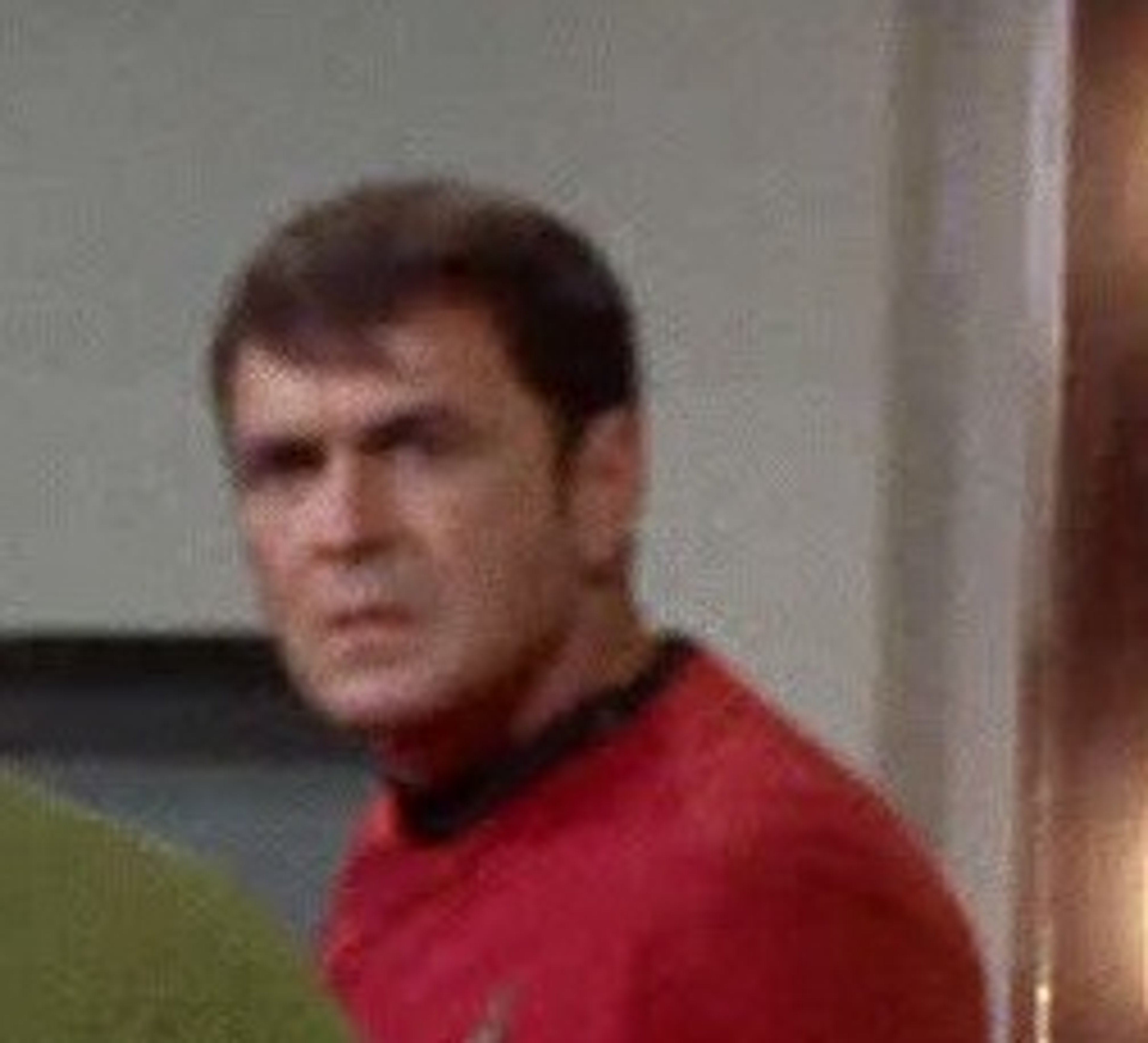 A man in a red uniform in a science fiction setting