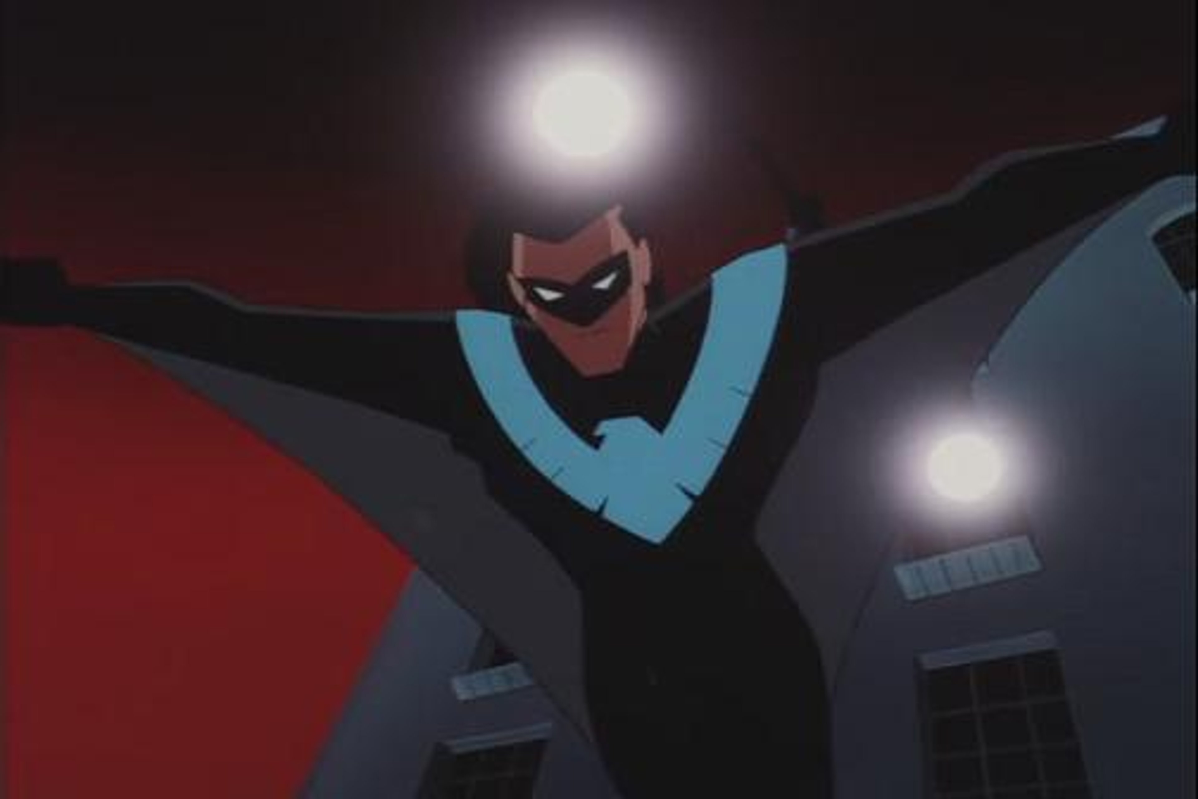 A male superhero character in a black and blue costume with a bird emblem on the chest, standing in a dramatic pose.