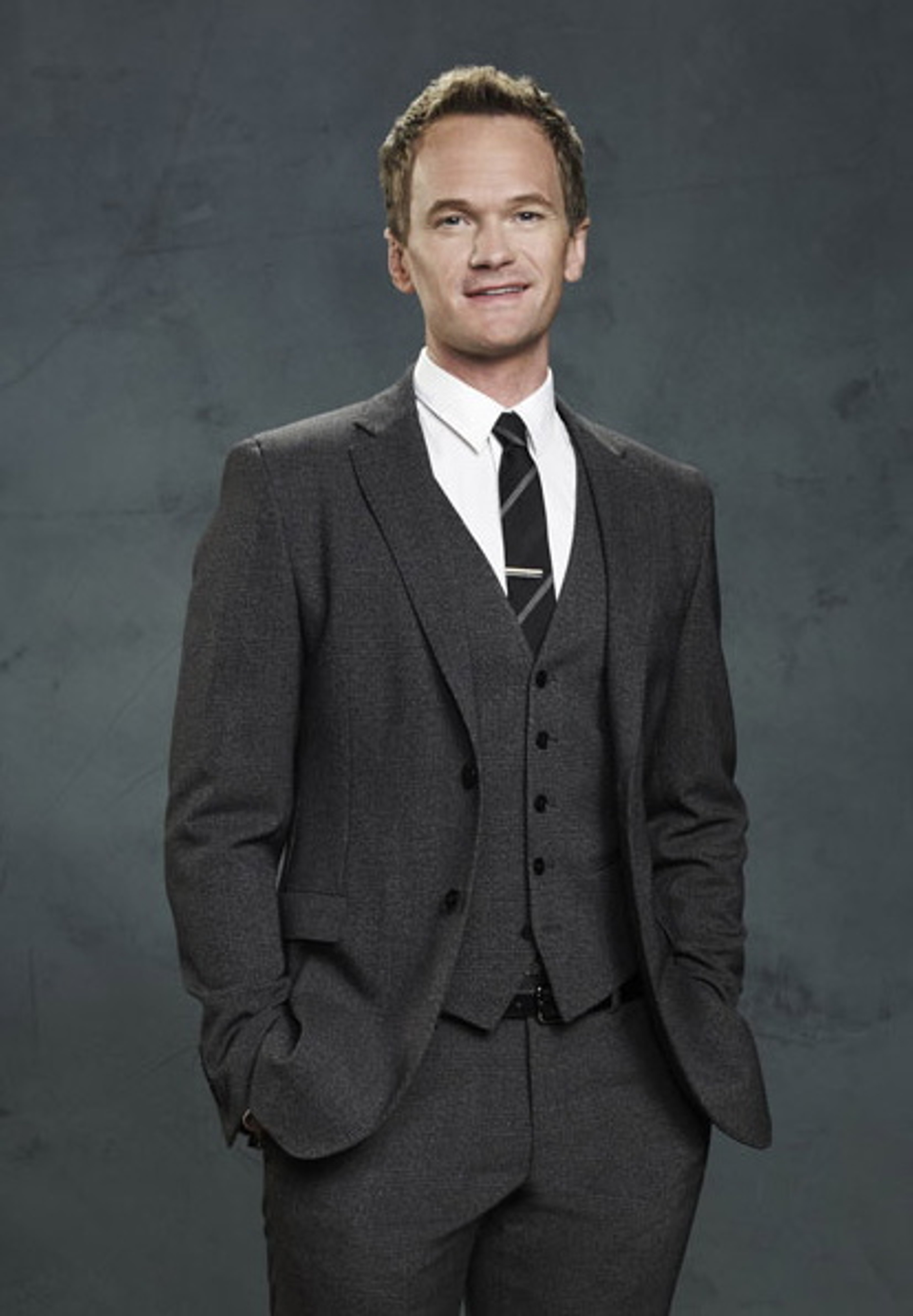 A man in a suit standing in a dark background