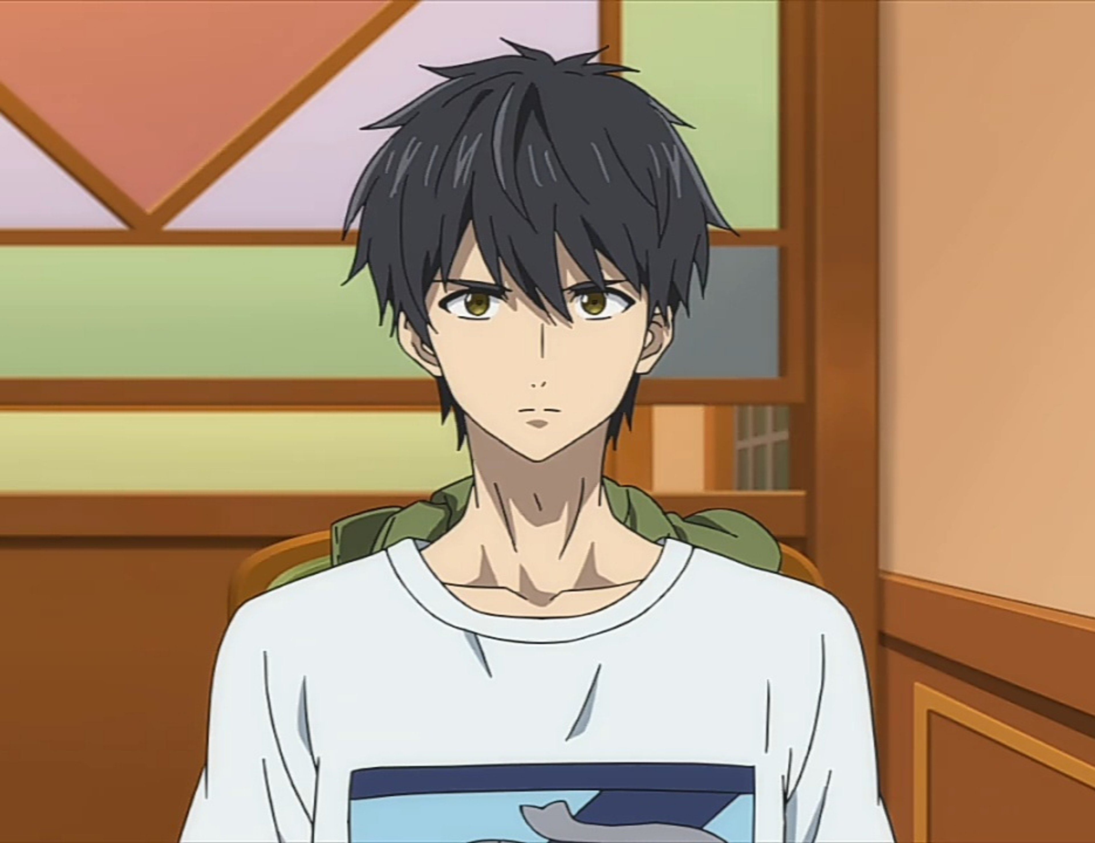 A young man with black hair and yellow eyes wearing a casual outfit
