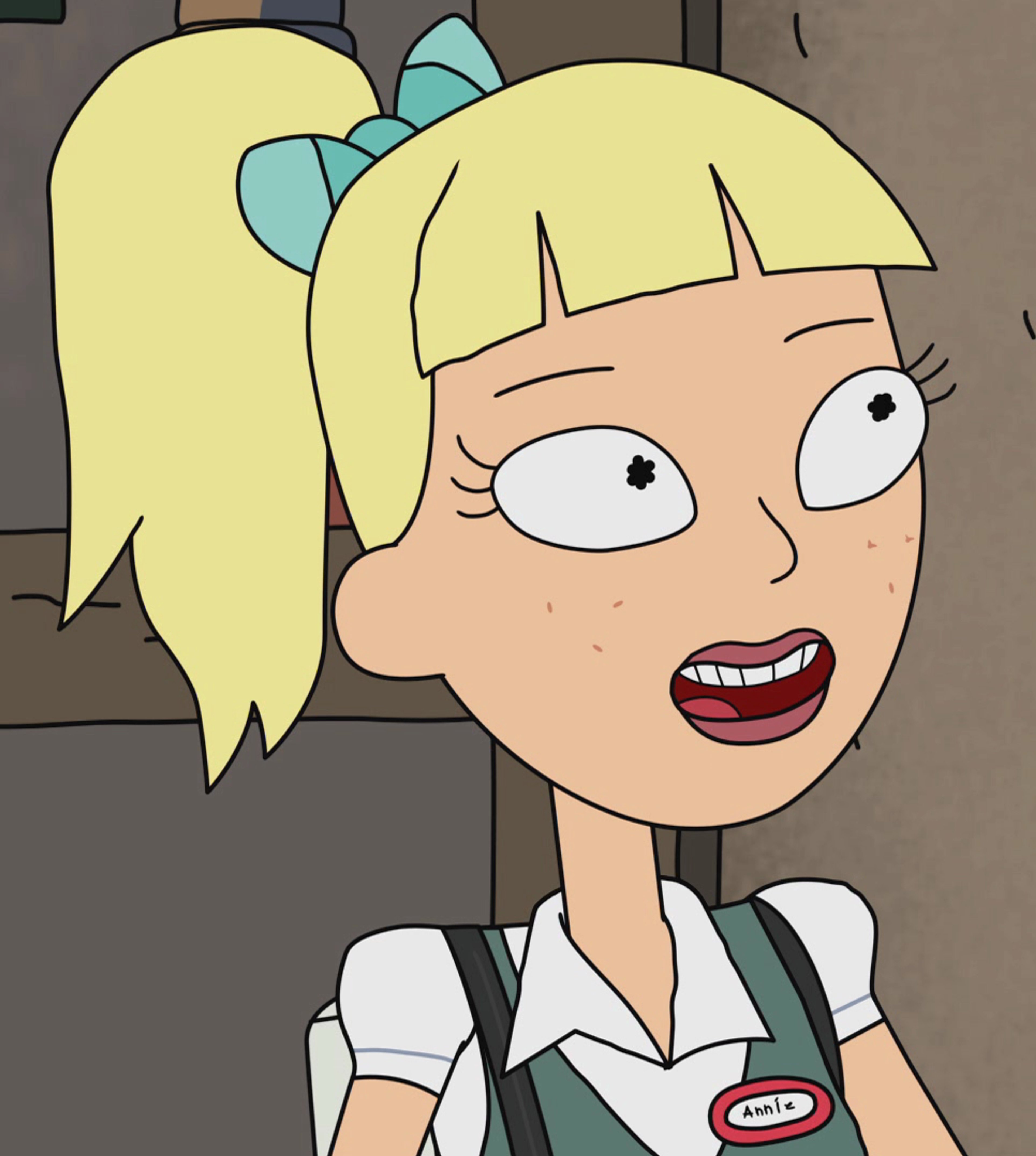 A cartoon image of a young, blonde-haired teenage girl in a green uniform or jumpsuit, smiling cheerfully.