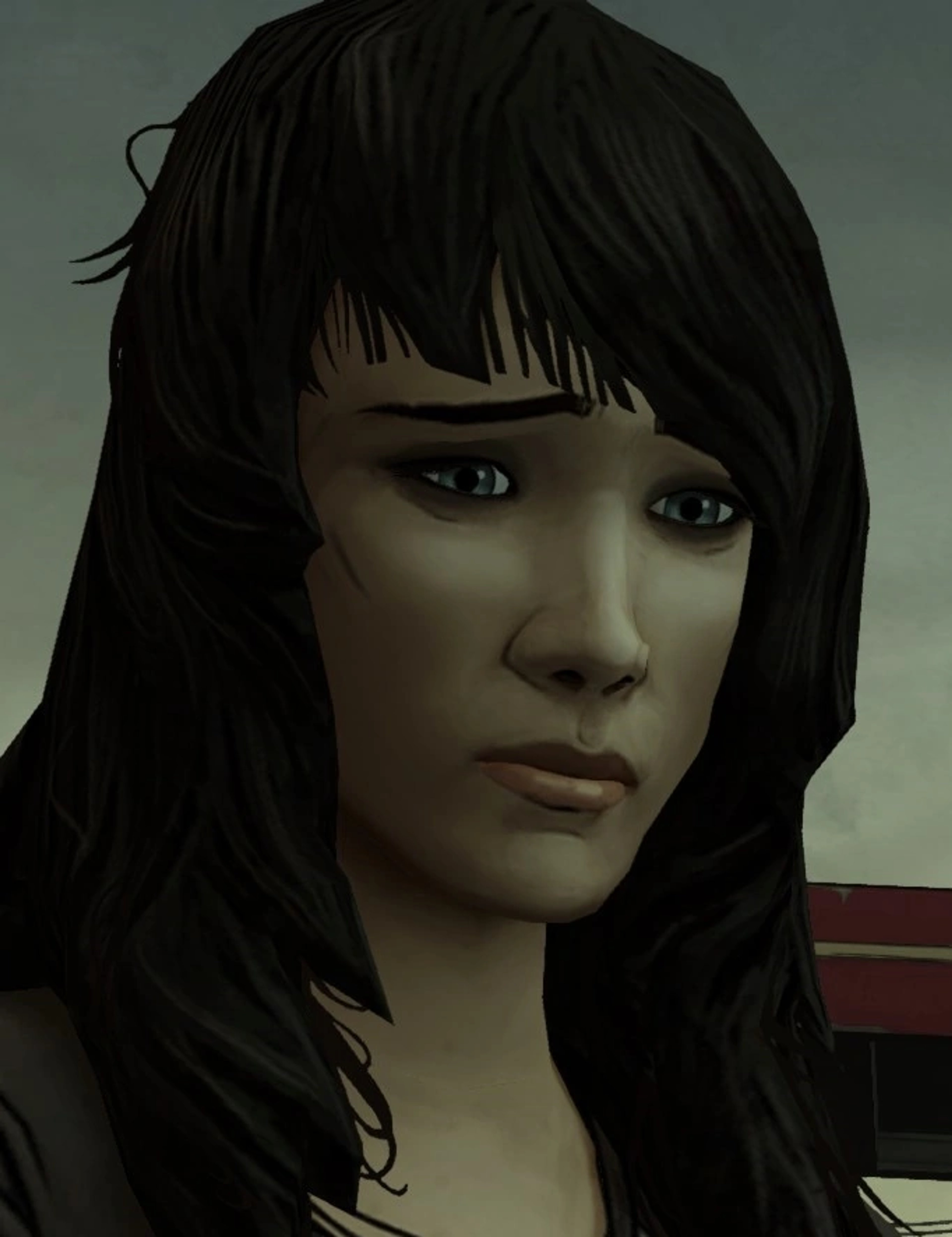 A young woman with short black hair and blue eyes, wearing practical clothing and having a serious expression.