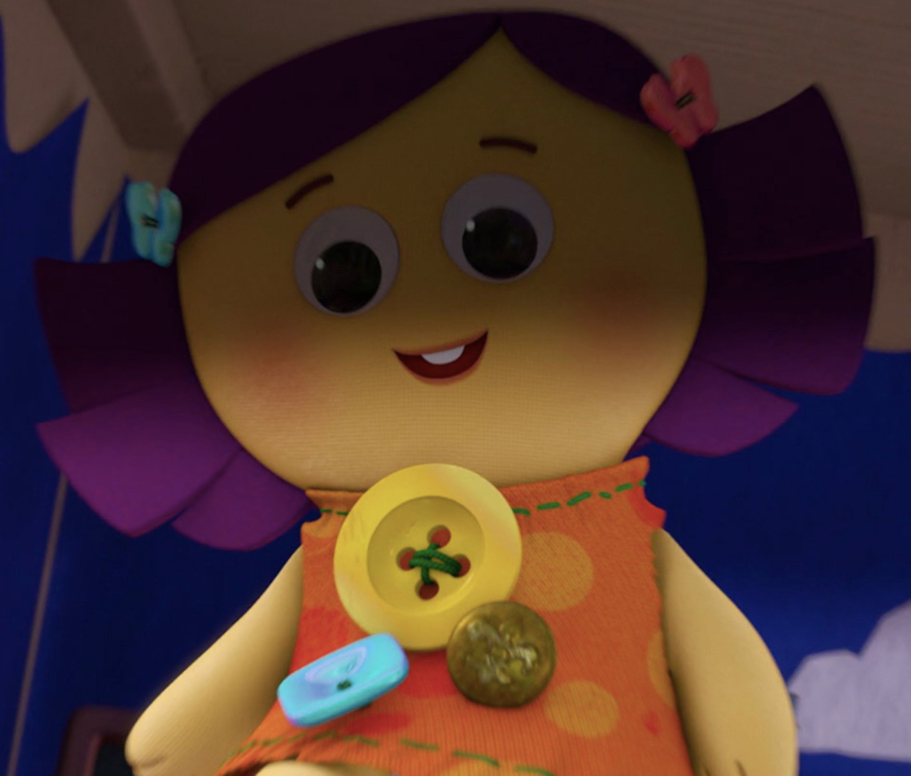 A soft, smiling rag doll with purple yarn hair and a blue dress