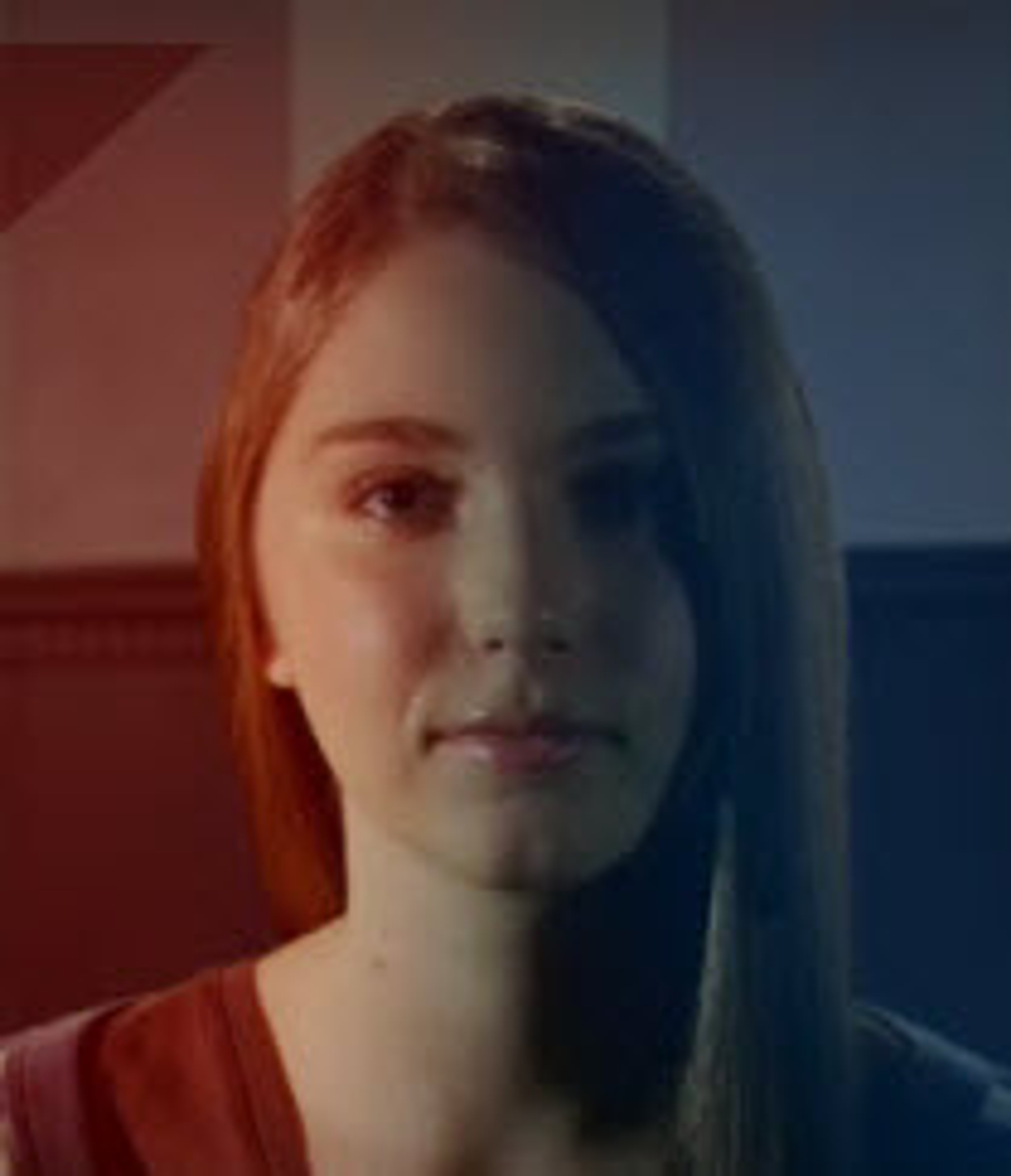 A young woman with reddish-brown hair and jade-green eyes