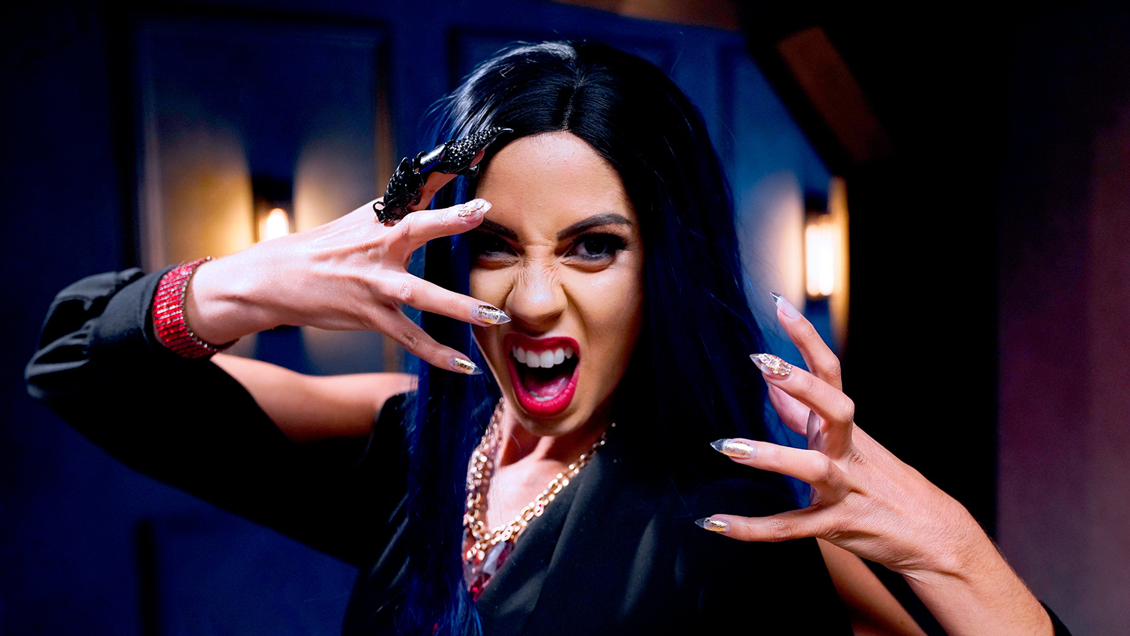 A woman with dark hair making an intense, dramatic gesture