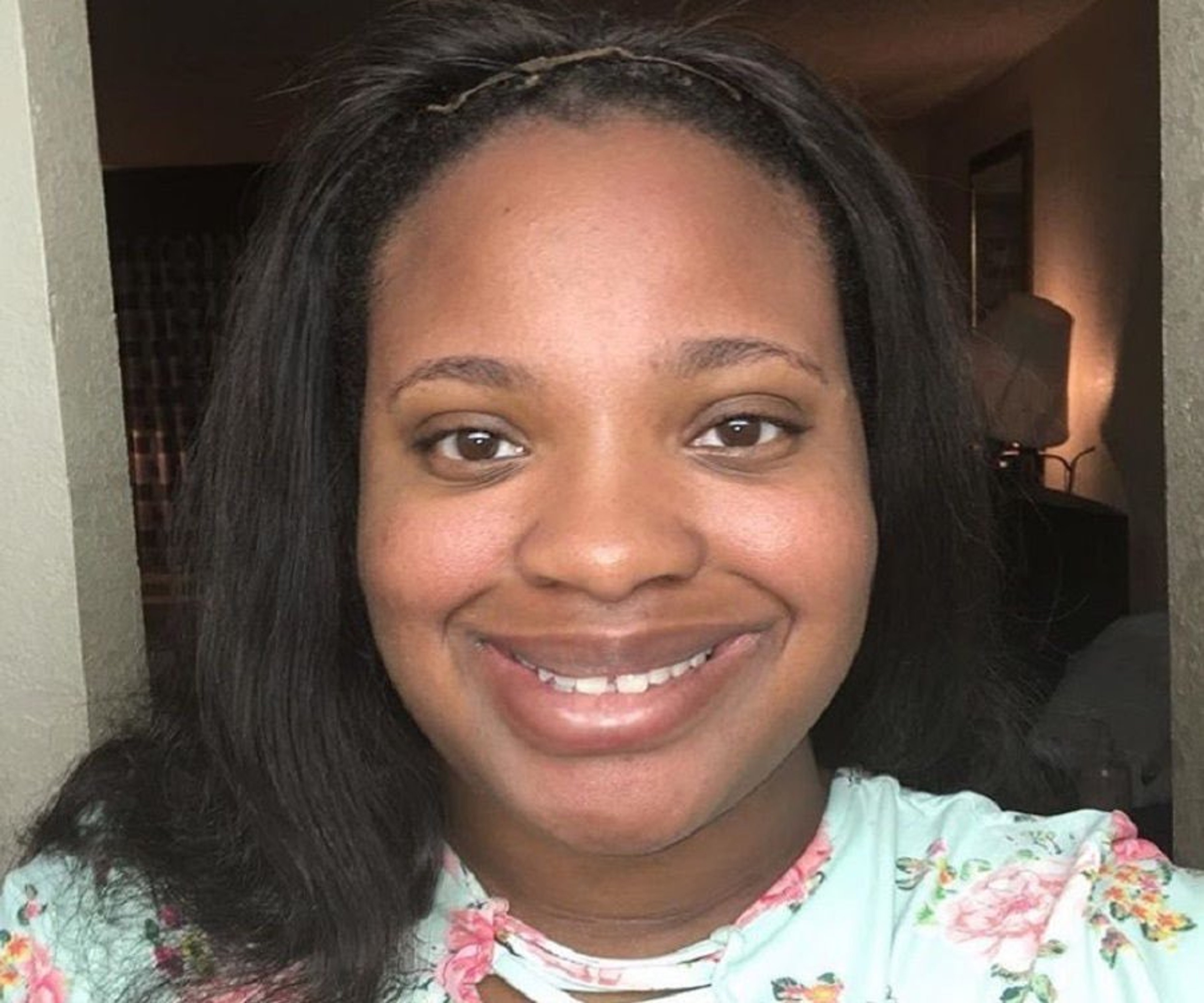 A smiling young Black woman with long dark hair