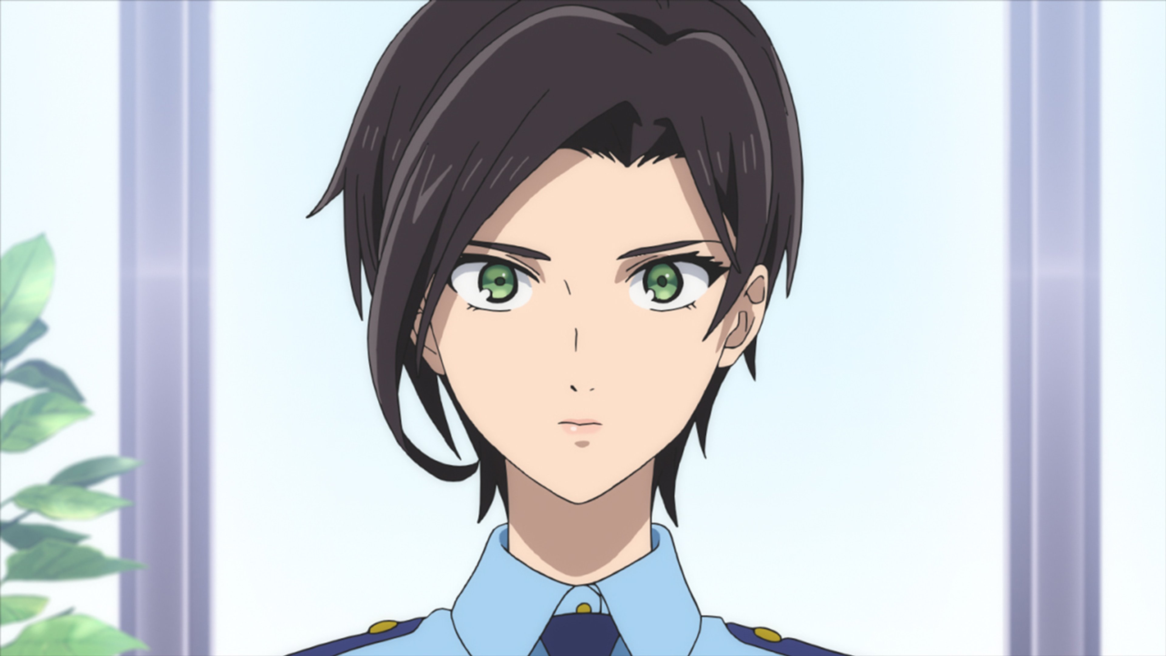 A young woman in a police uniform with black hair and green eyes