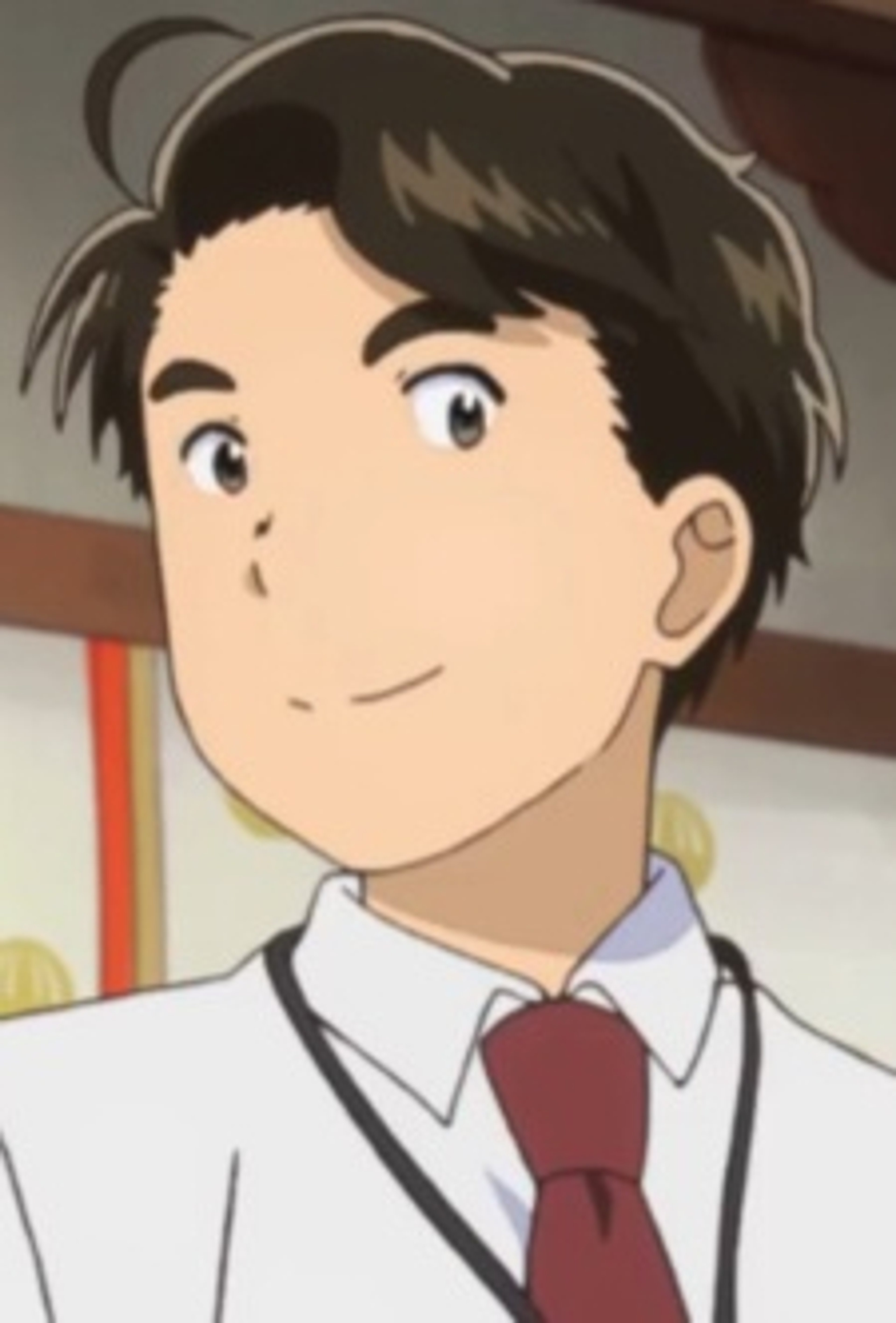 A young man with short brown hair wearing a button-down shirt and tie