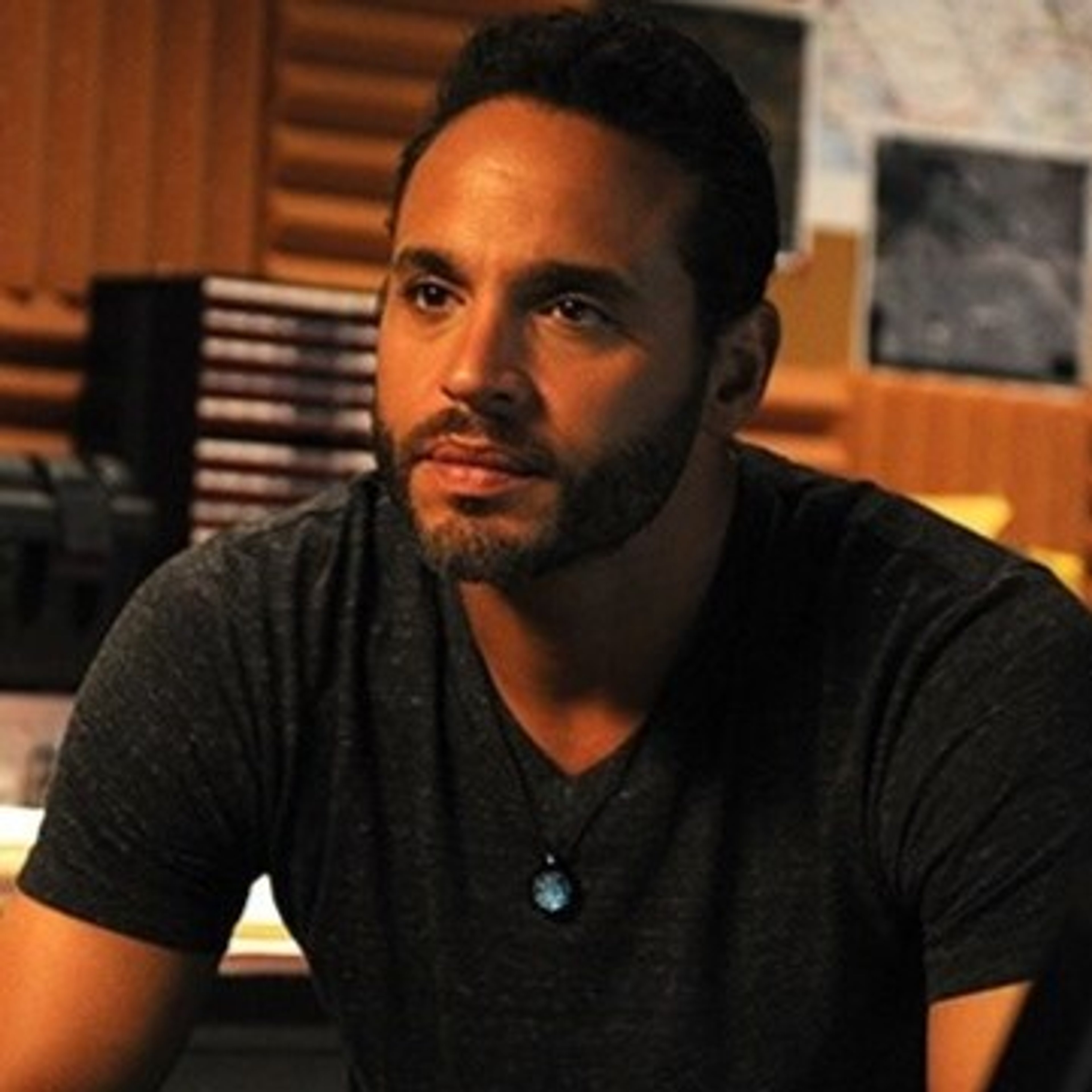 A middle-aged man with a serious expression, wearing a black t-shirt