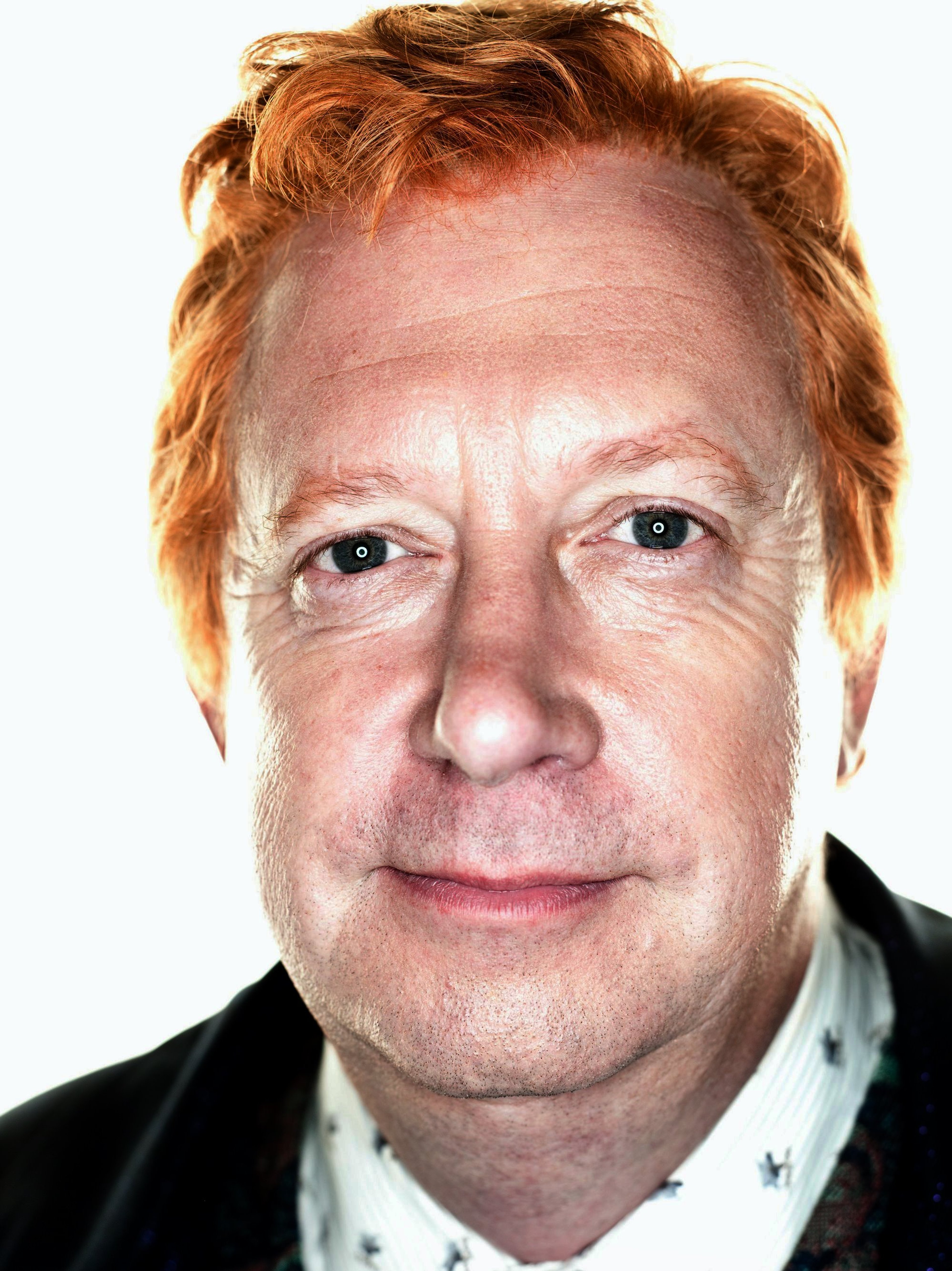 An older man with reddish-brown hair and a friendly expression