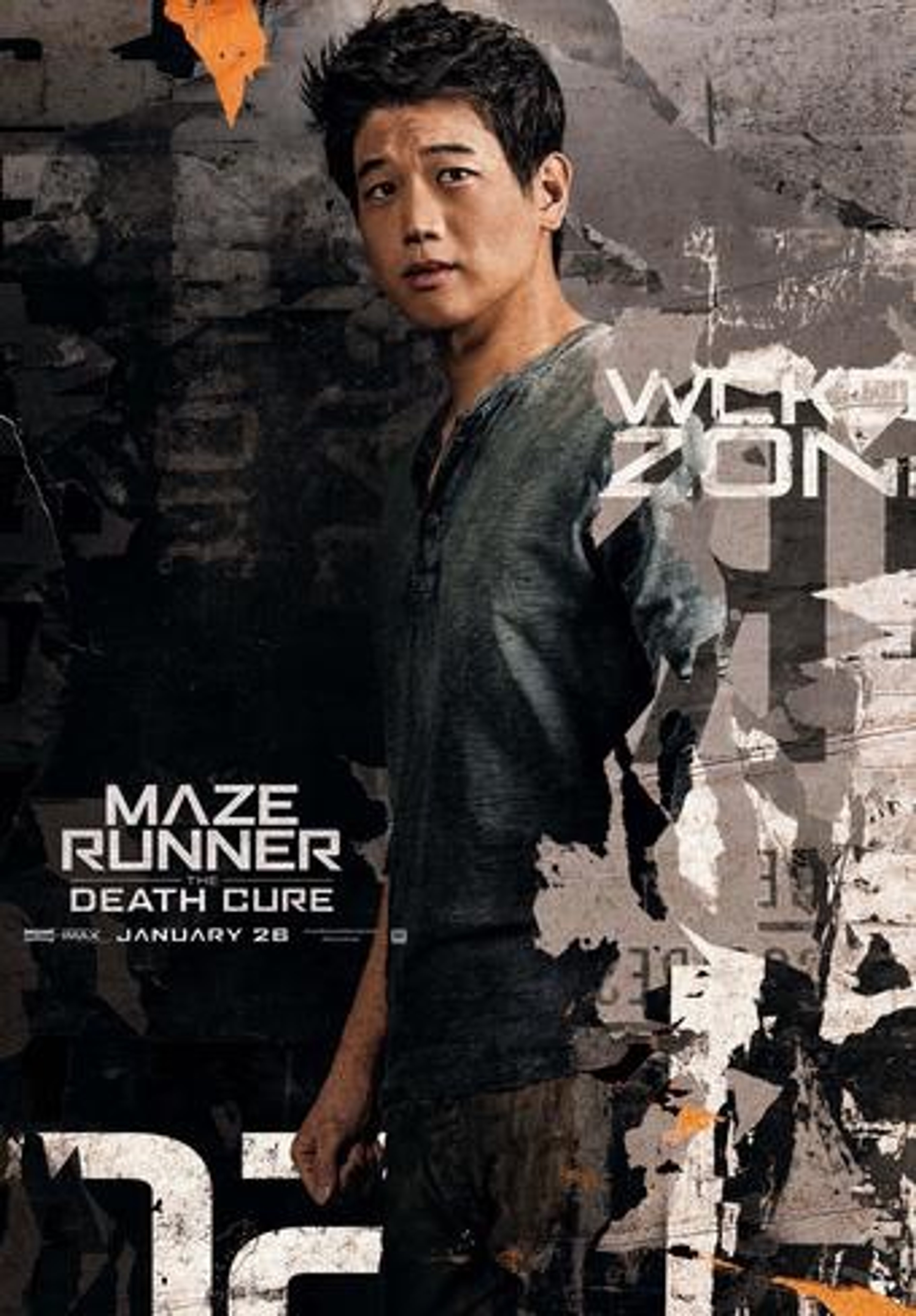 A young Asian man with short dark hair wearing a green jacket, standing in an urban setting with graffiti-covered walls in the background.