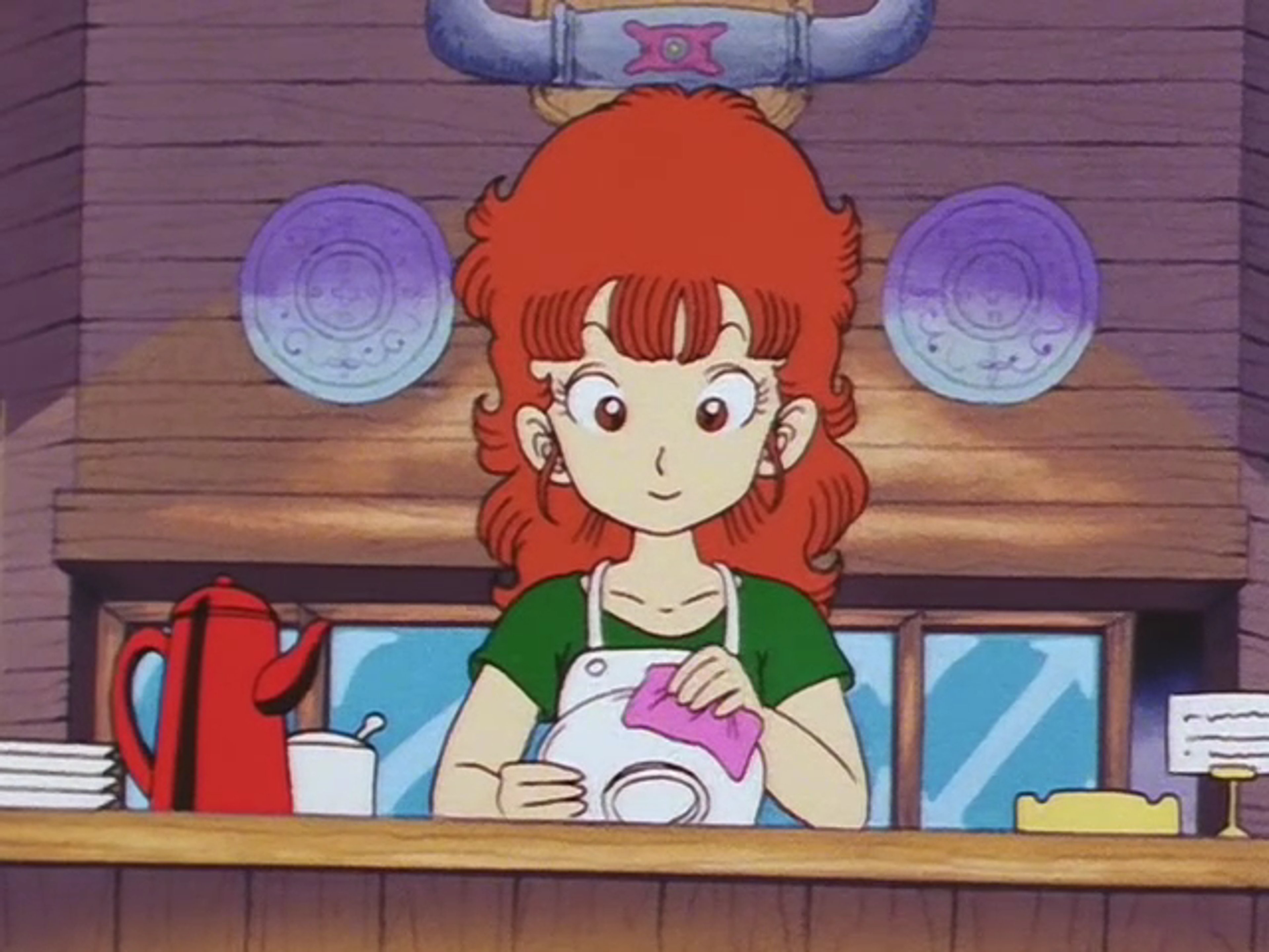 A young woman with red hair working at a café counter