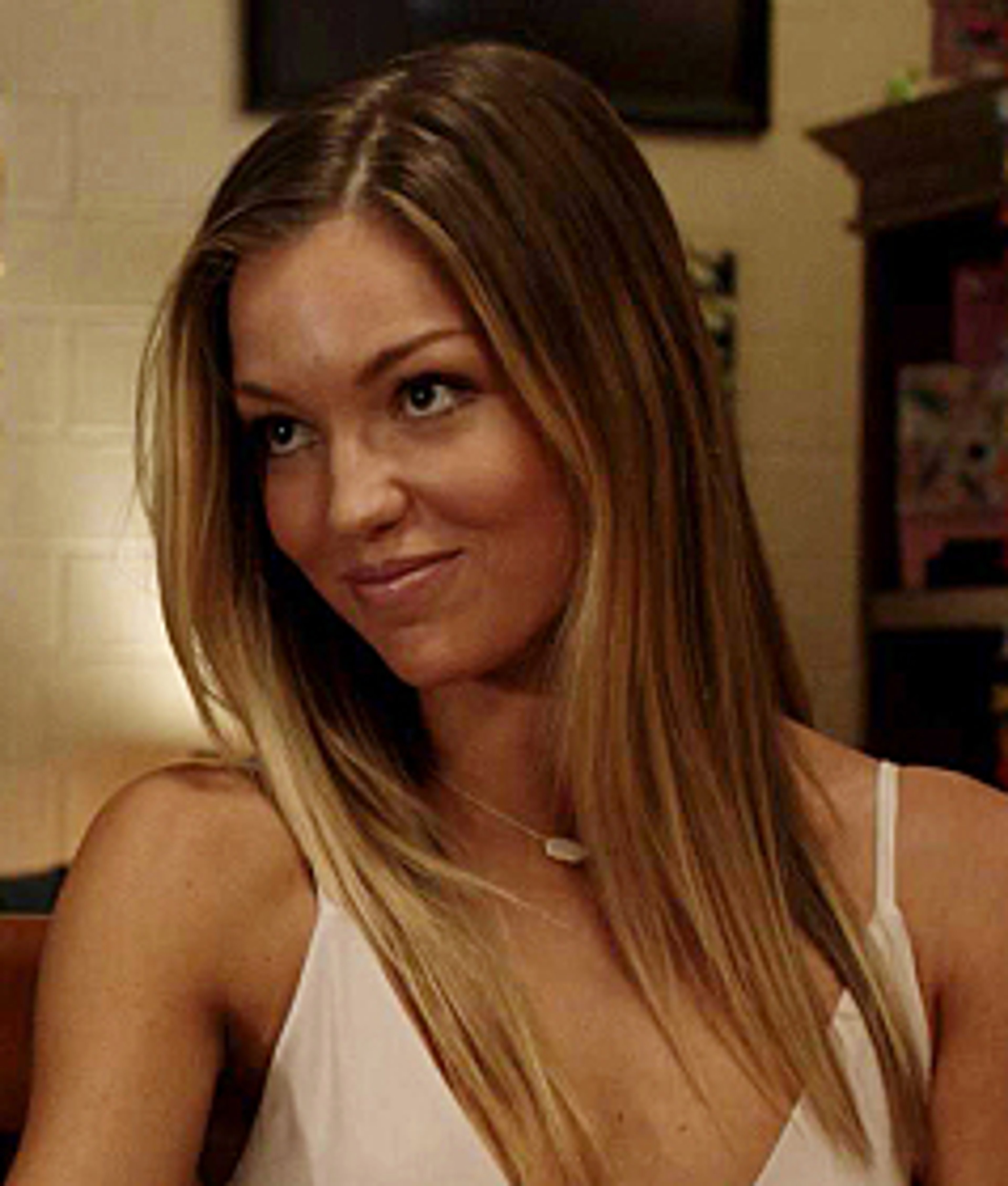 A young woman with long blonde hair and a friendly expression