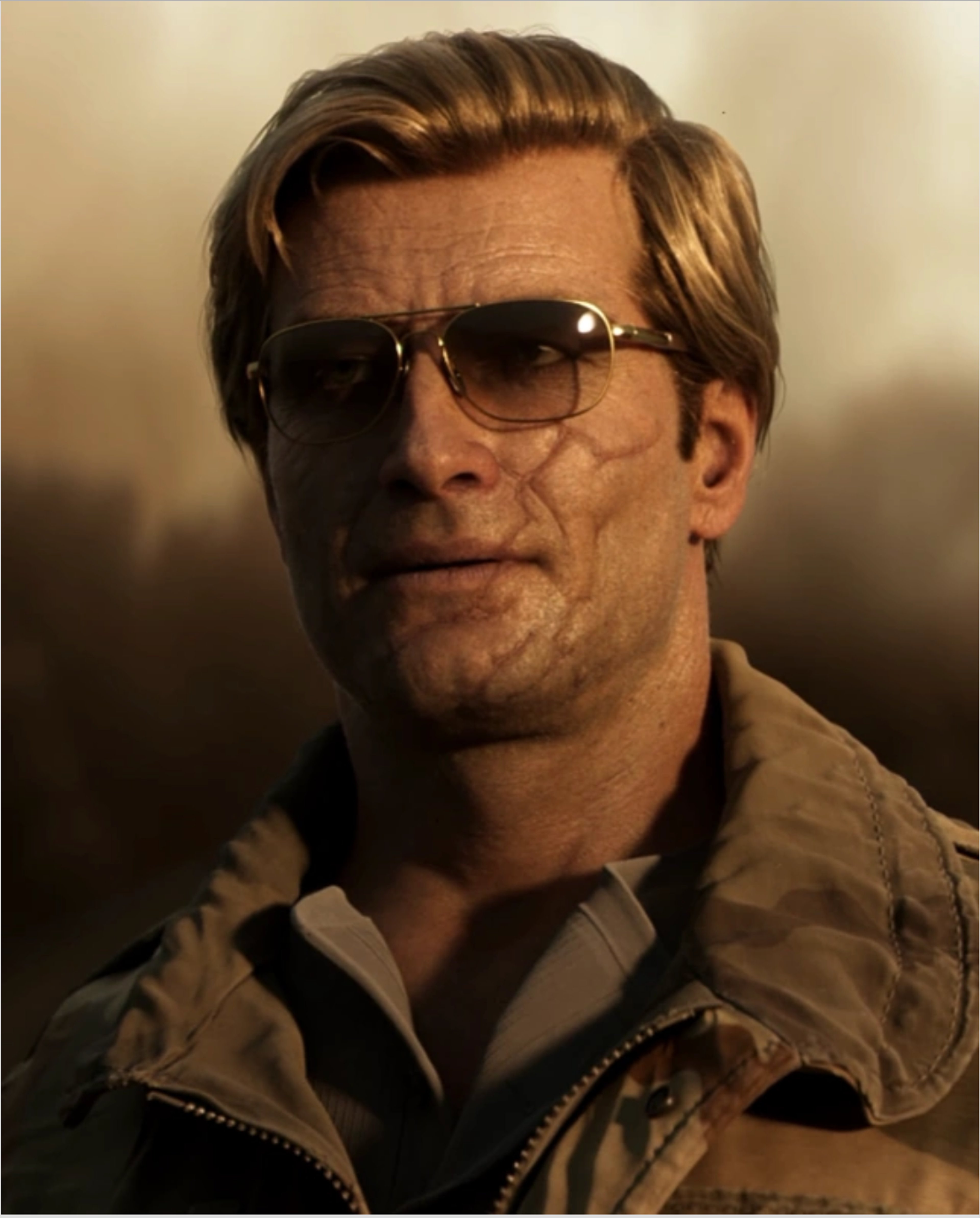 A middle-aged man with short blonde hair and sunglasses, wearing a tan jacket, with a serious expression on his face.