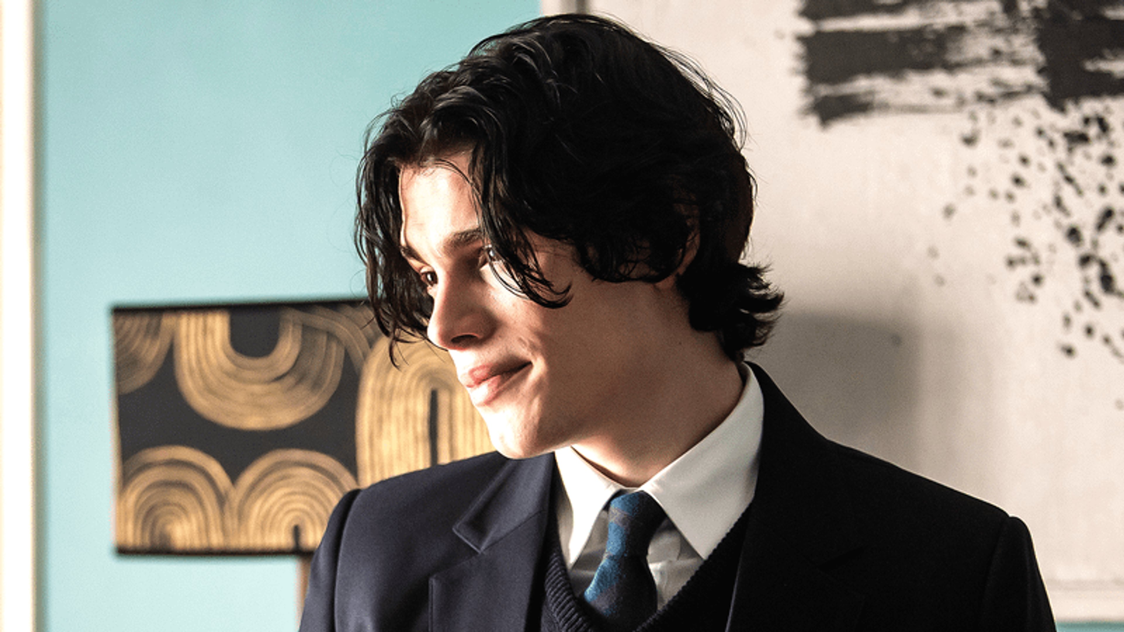 A young man in a suit and tie with a serious expression
