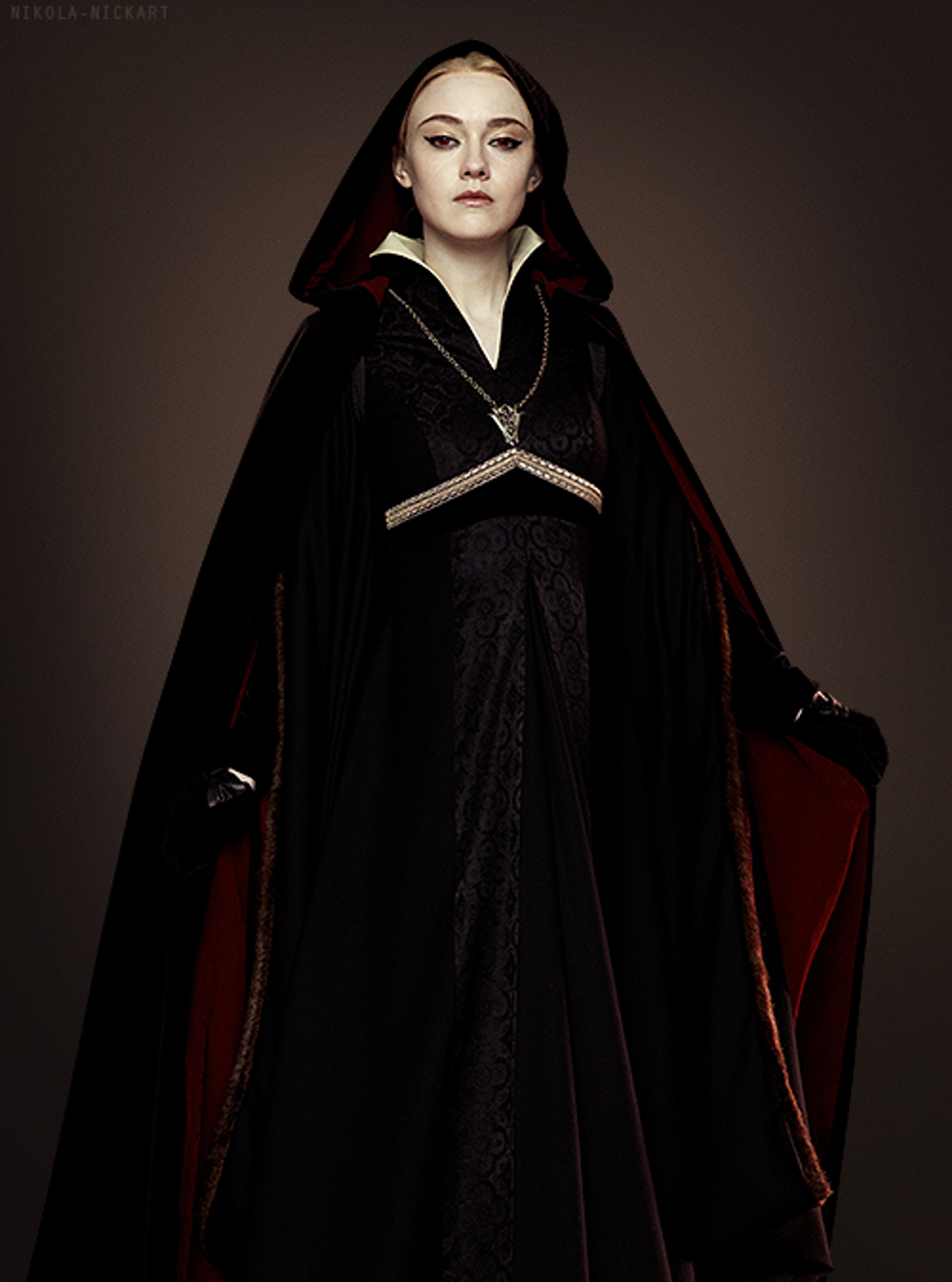 A young woman in a dark hooded robe with a cherubic, intense expression