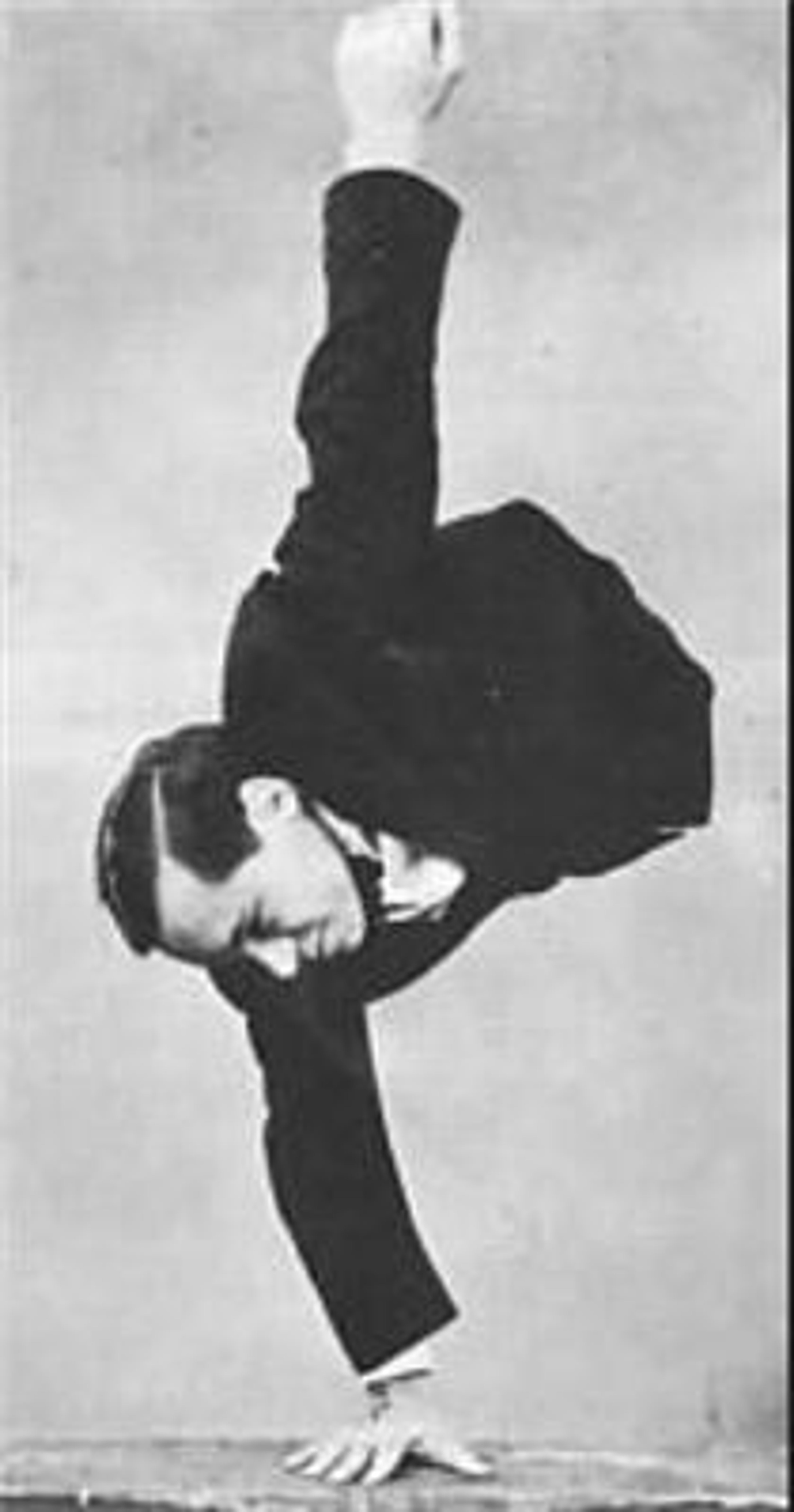 A man with a truncated torso and no legs performing an acrobatic handstand.