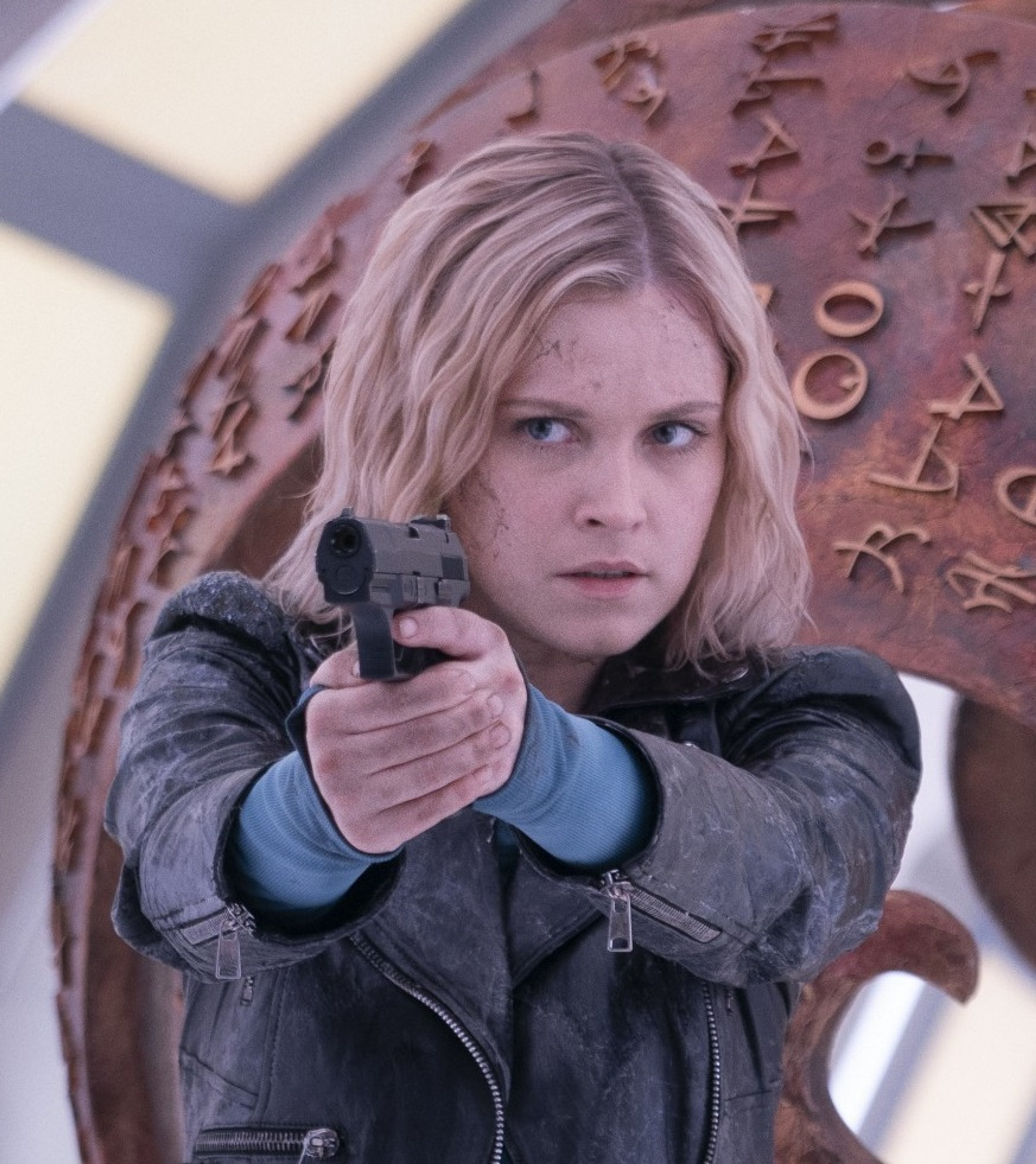 A young woman with a handgun in a threatening pose