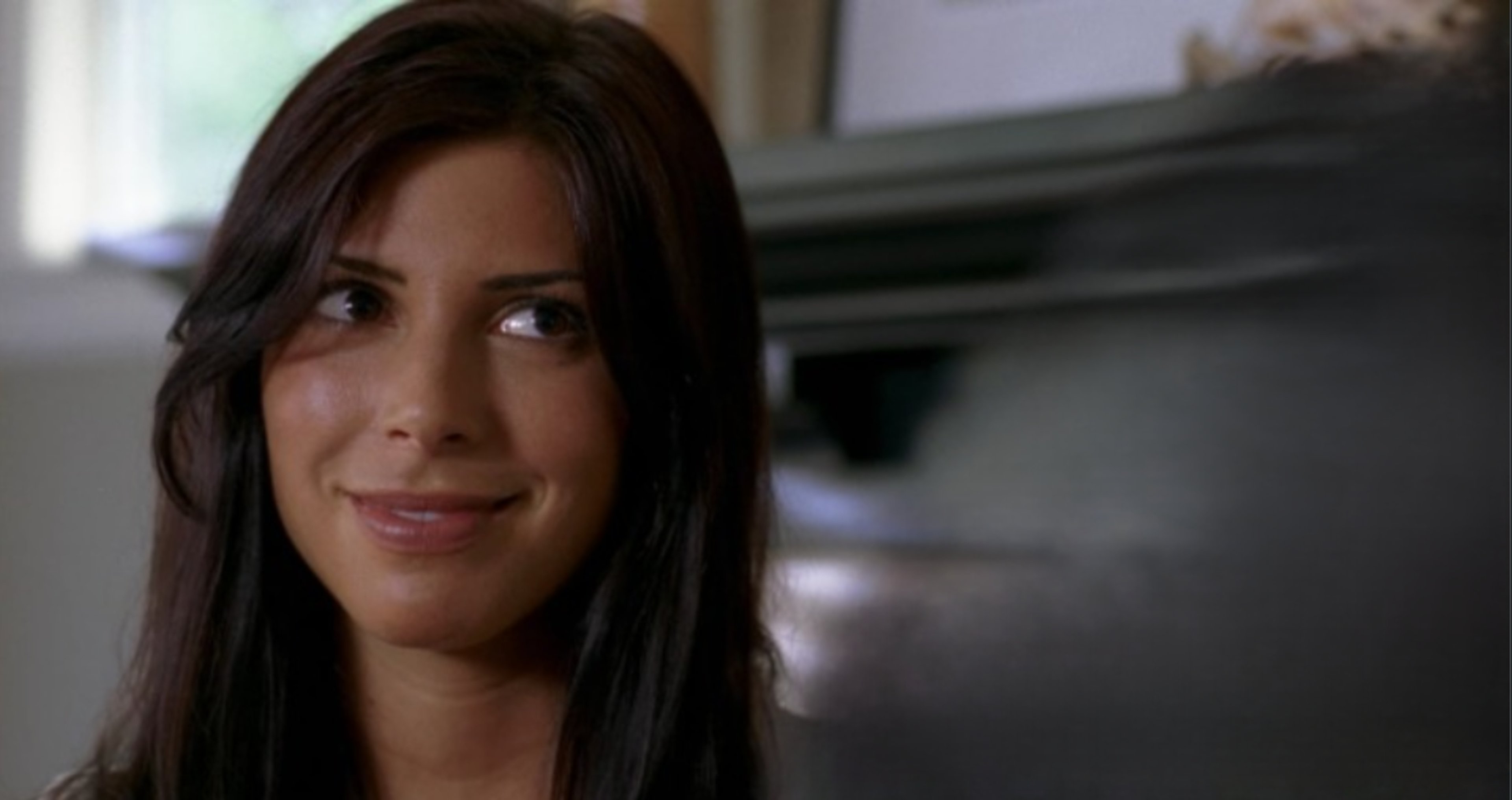 A woman with long dark hair smiling at the camera