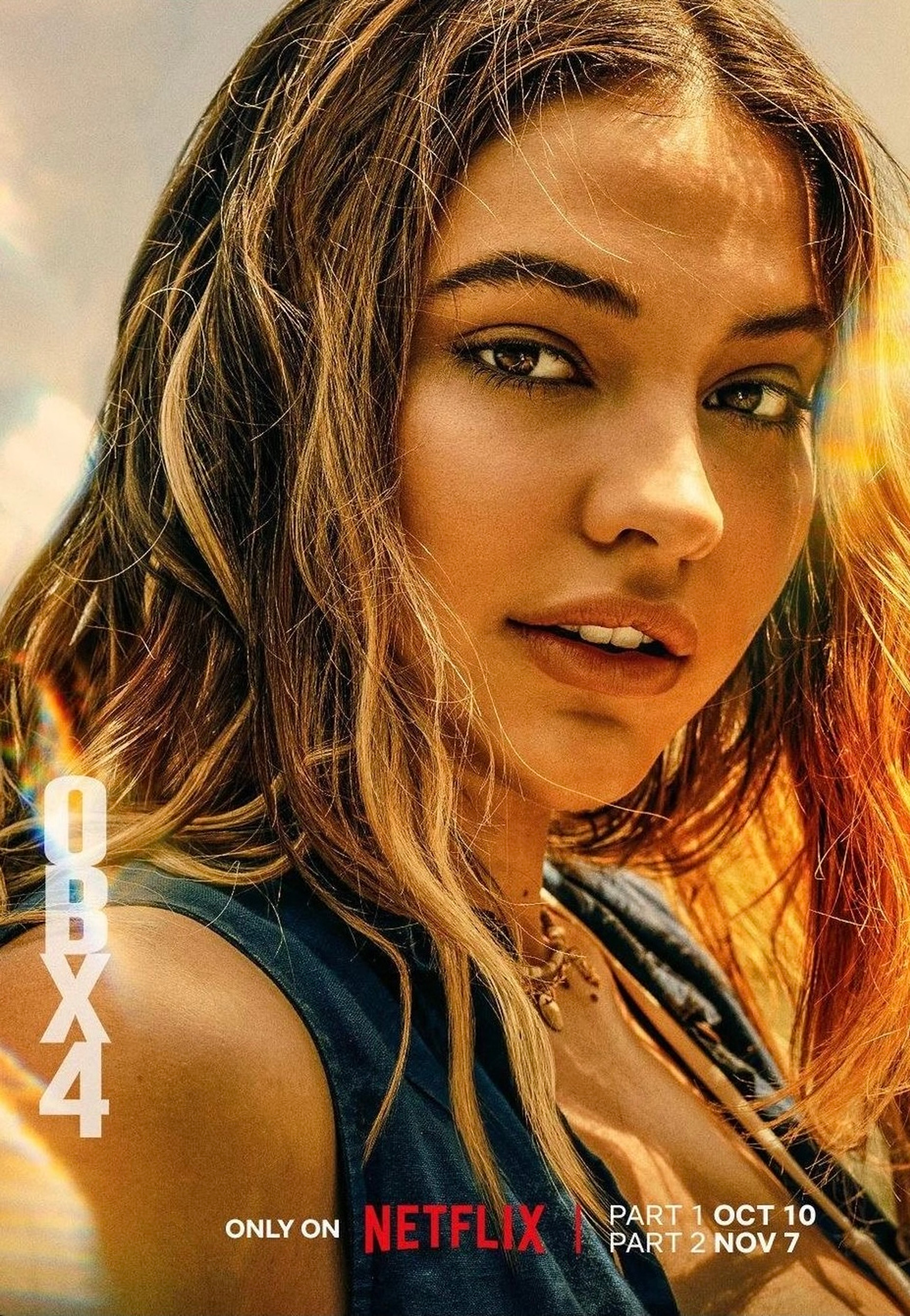 A young woman with long brown hair and a serious expression, wearing a blue denim jacket.