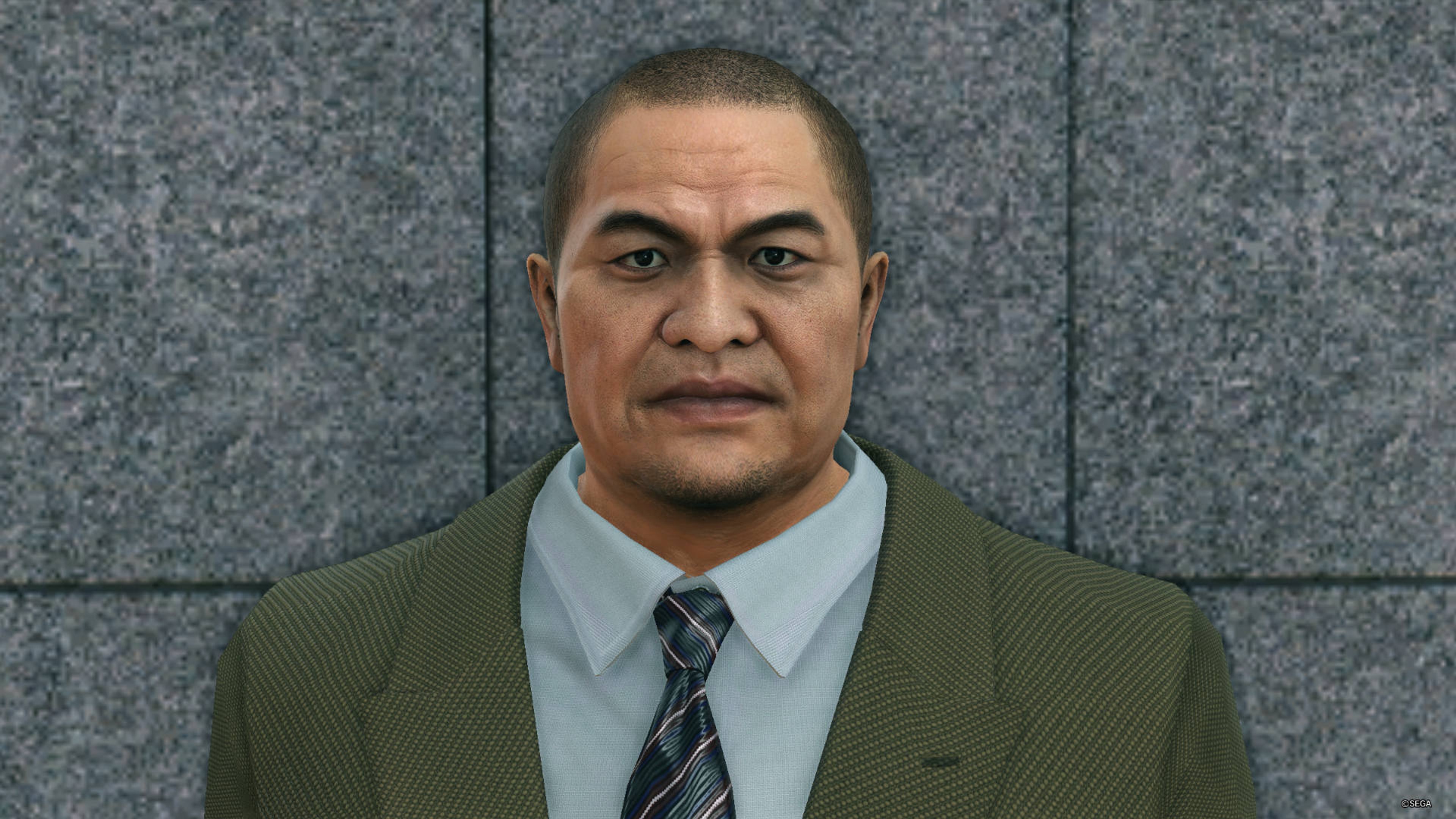 A middle-aged Asian man in a suit with a stern expression