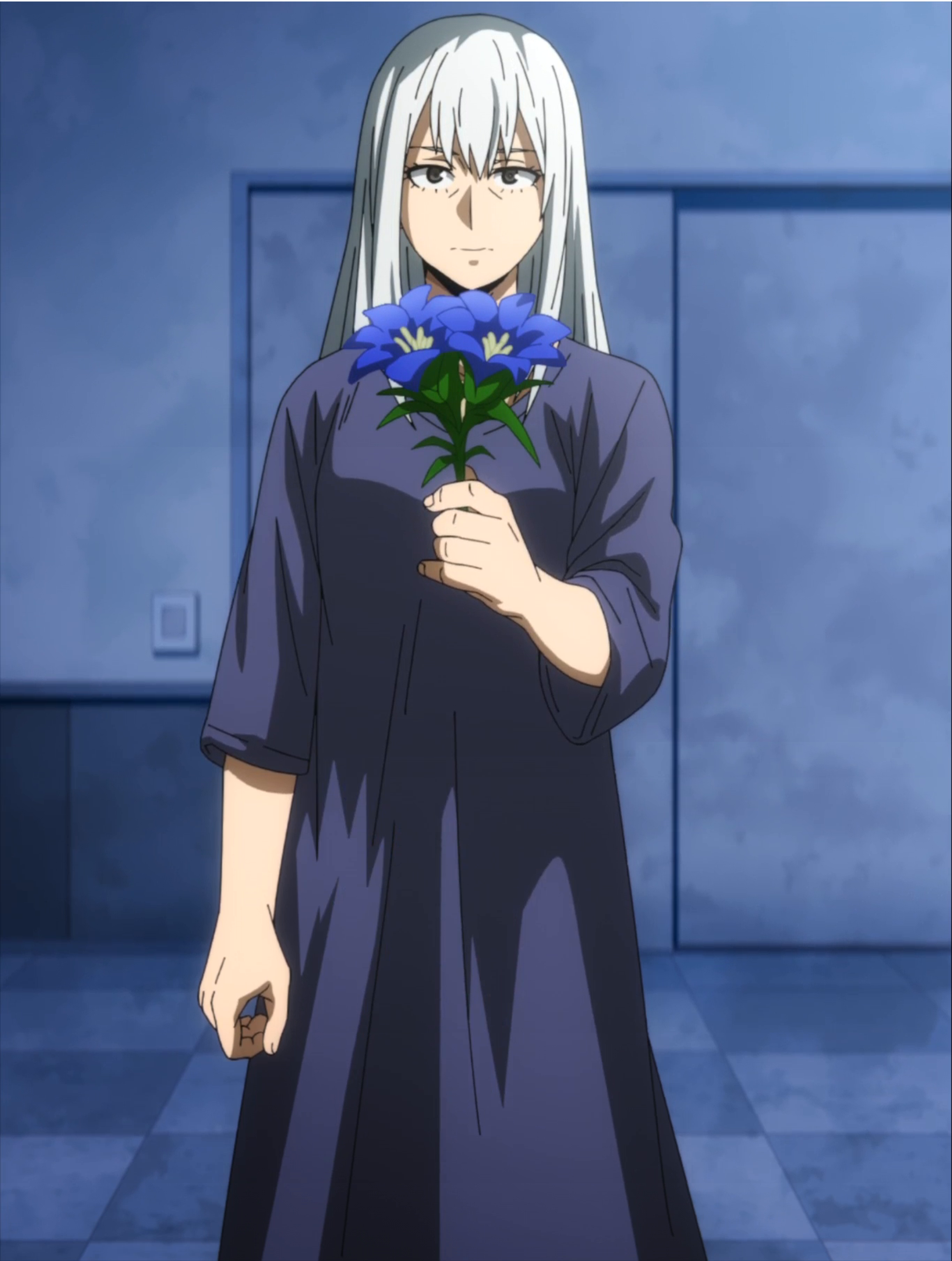 A middle-aged woman with silver-white hair holding a bouquet of blue flowers