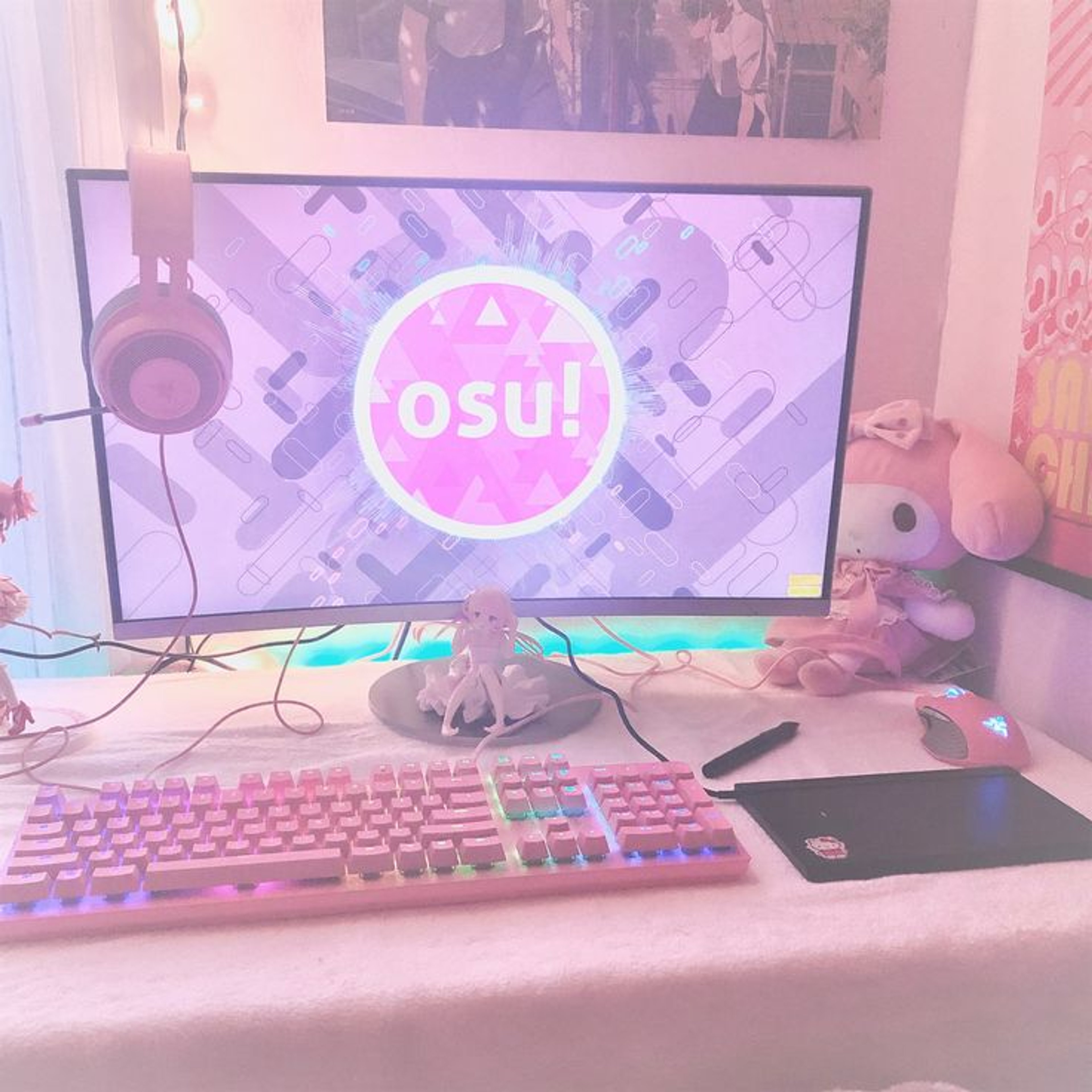 A computer setup with a large monitor displaying the OSU! logo, surrounded by kawaii-style decor and gaming peripherals.