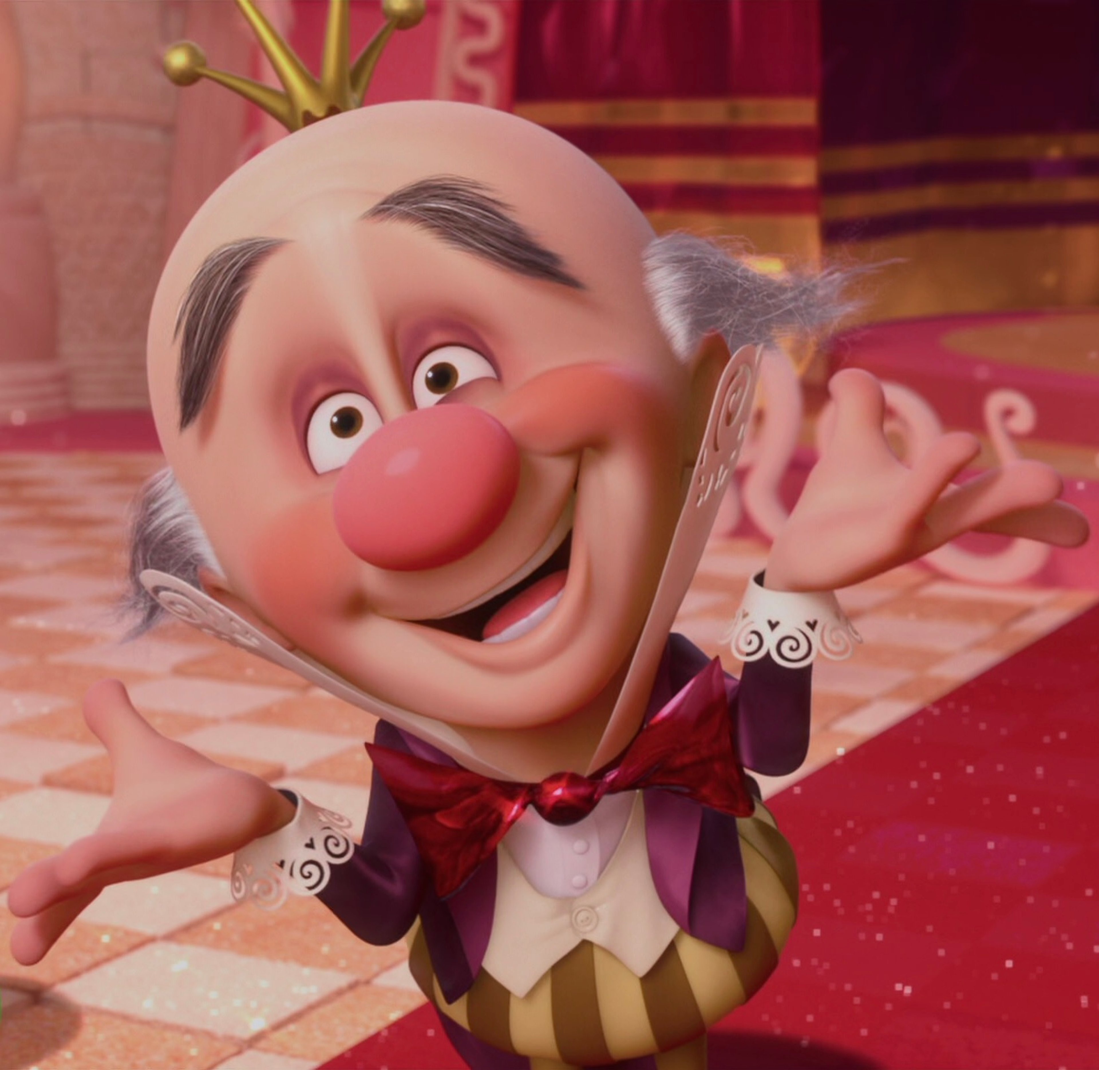 An animated character with a large, round head, red nose, and exaggerated facial features, wearing a colorful outfit with a bow tie and striking a theatrical pose.