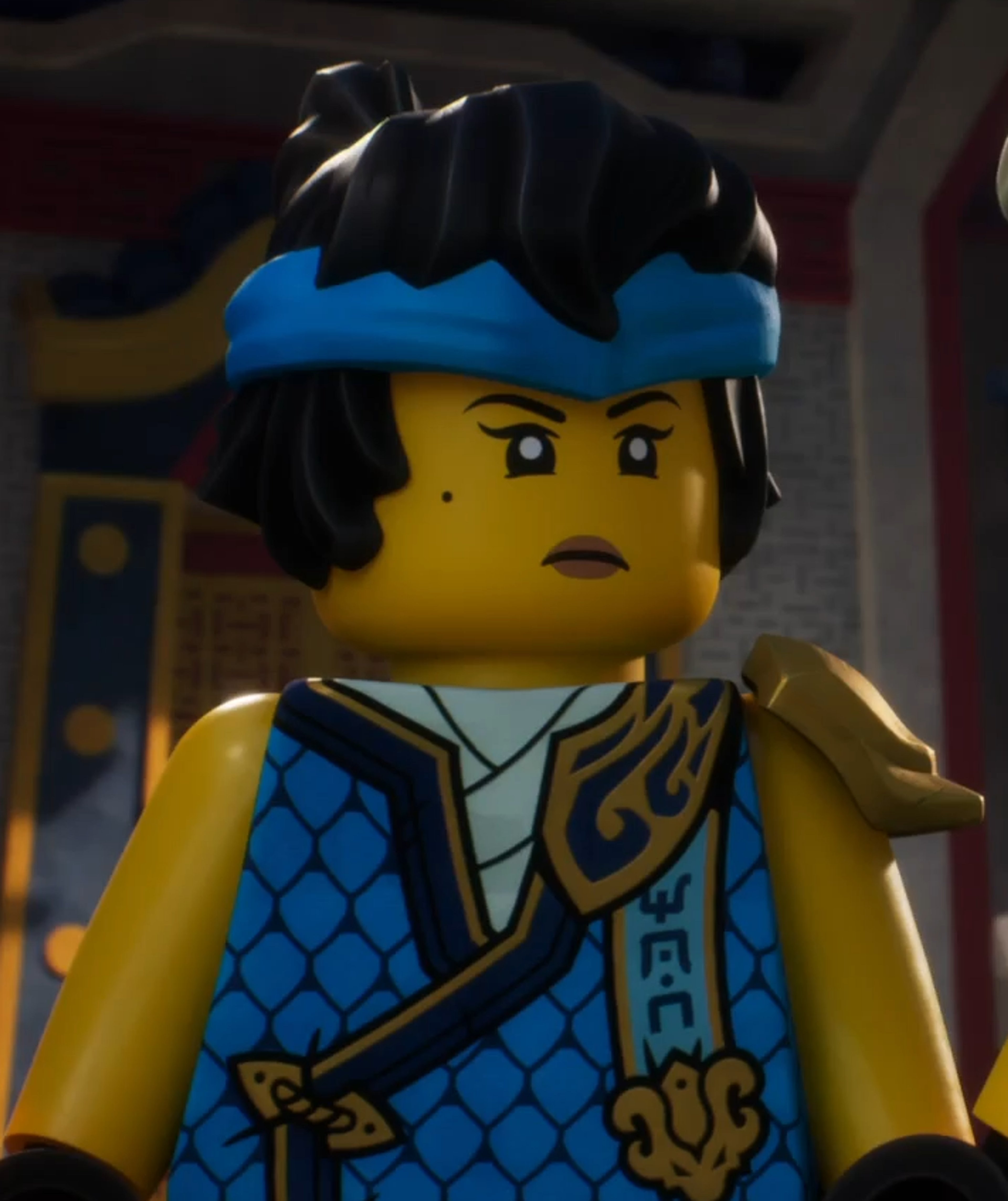 A LEGO minifigure of a female ninja character in a blue and gold outfit, with a determined expression on her face.