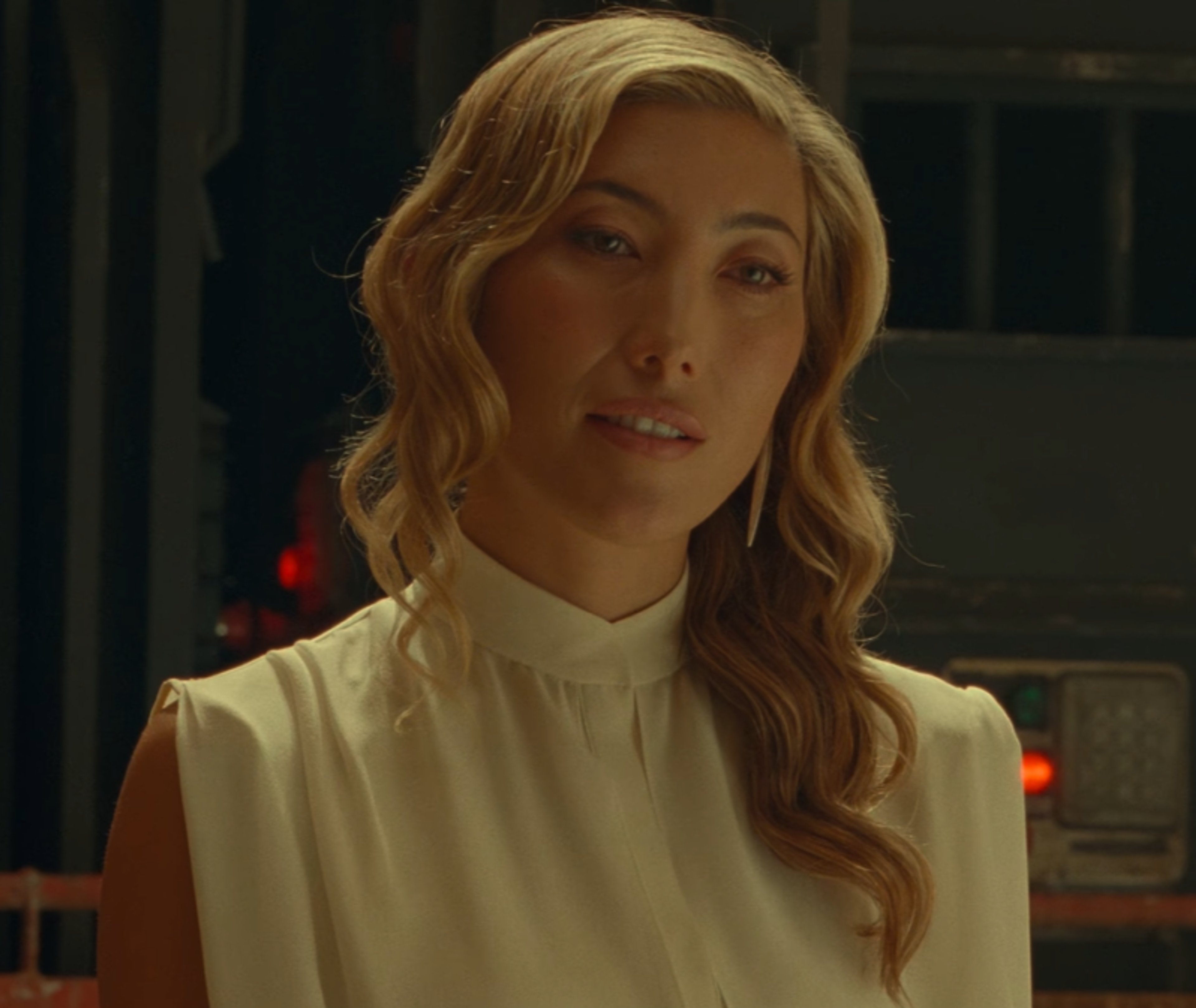 A woman with blonde hair wearing a white blouse