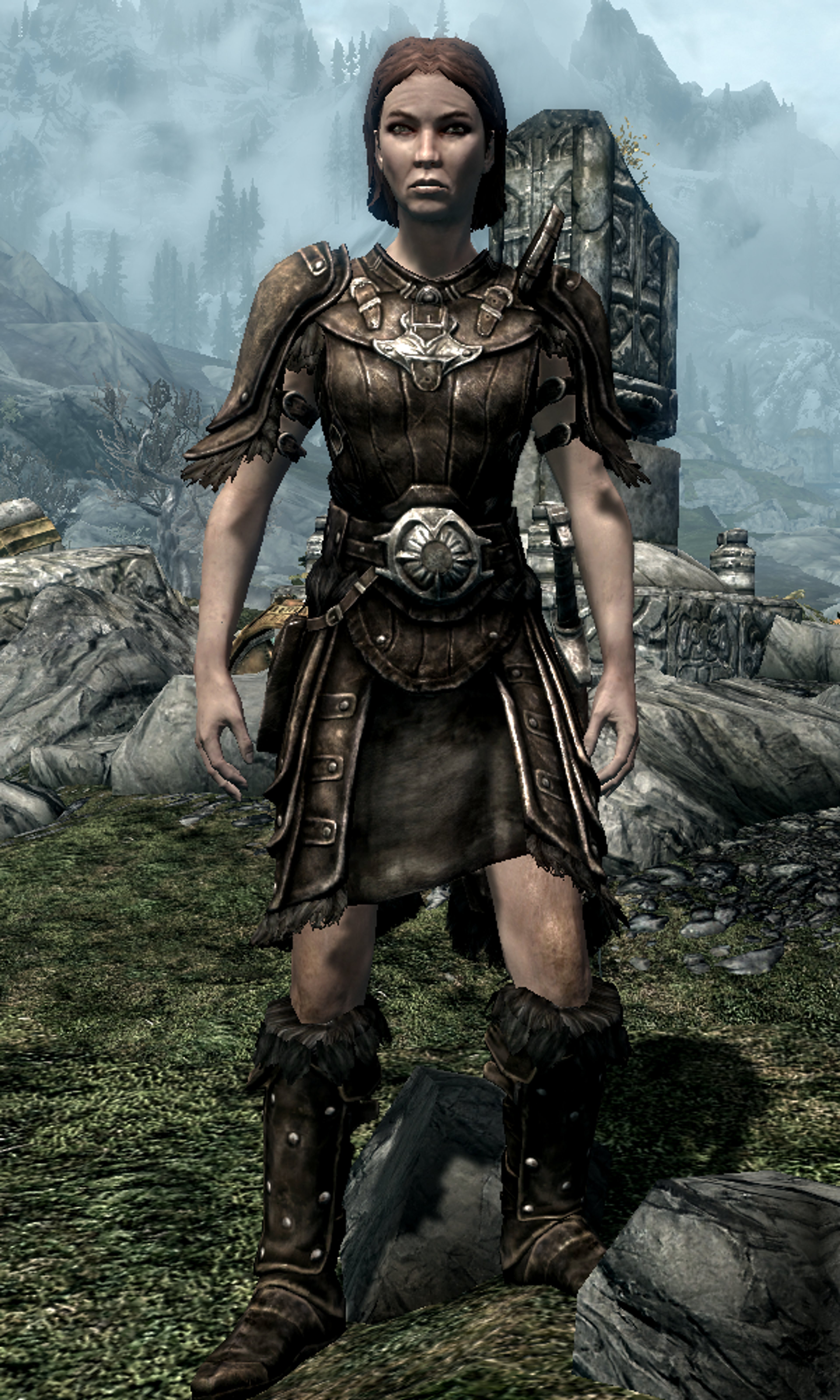 A female Breton character in Dwemer-style armor standing in a mountainous, forested environment.