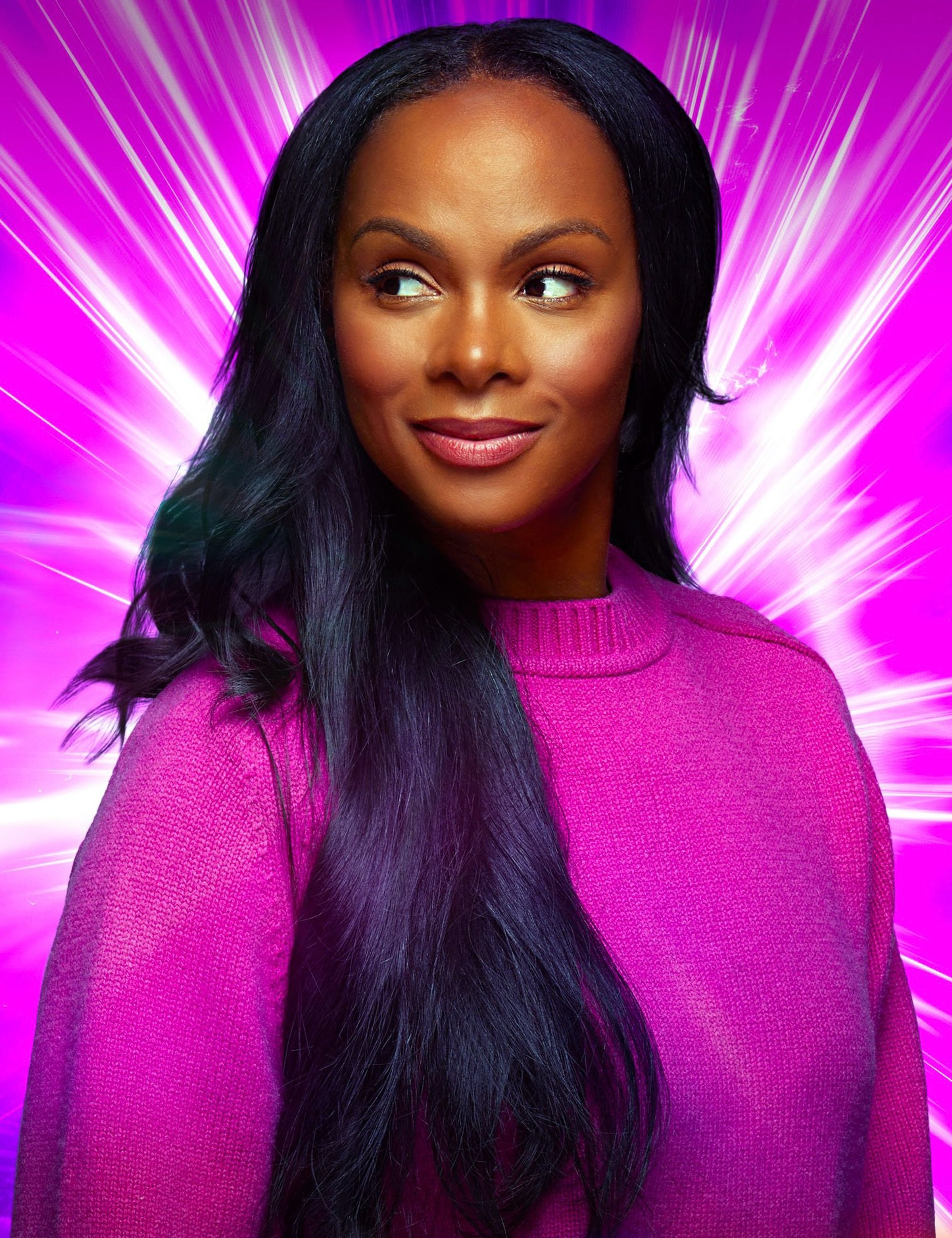 A woman with long dark hair wearing a pink sweater smiling at the camera