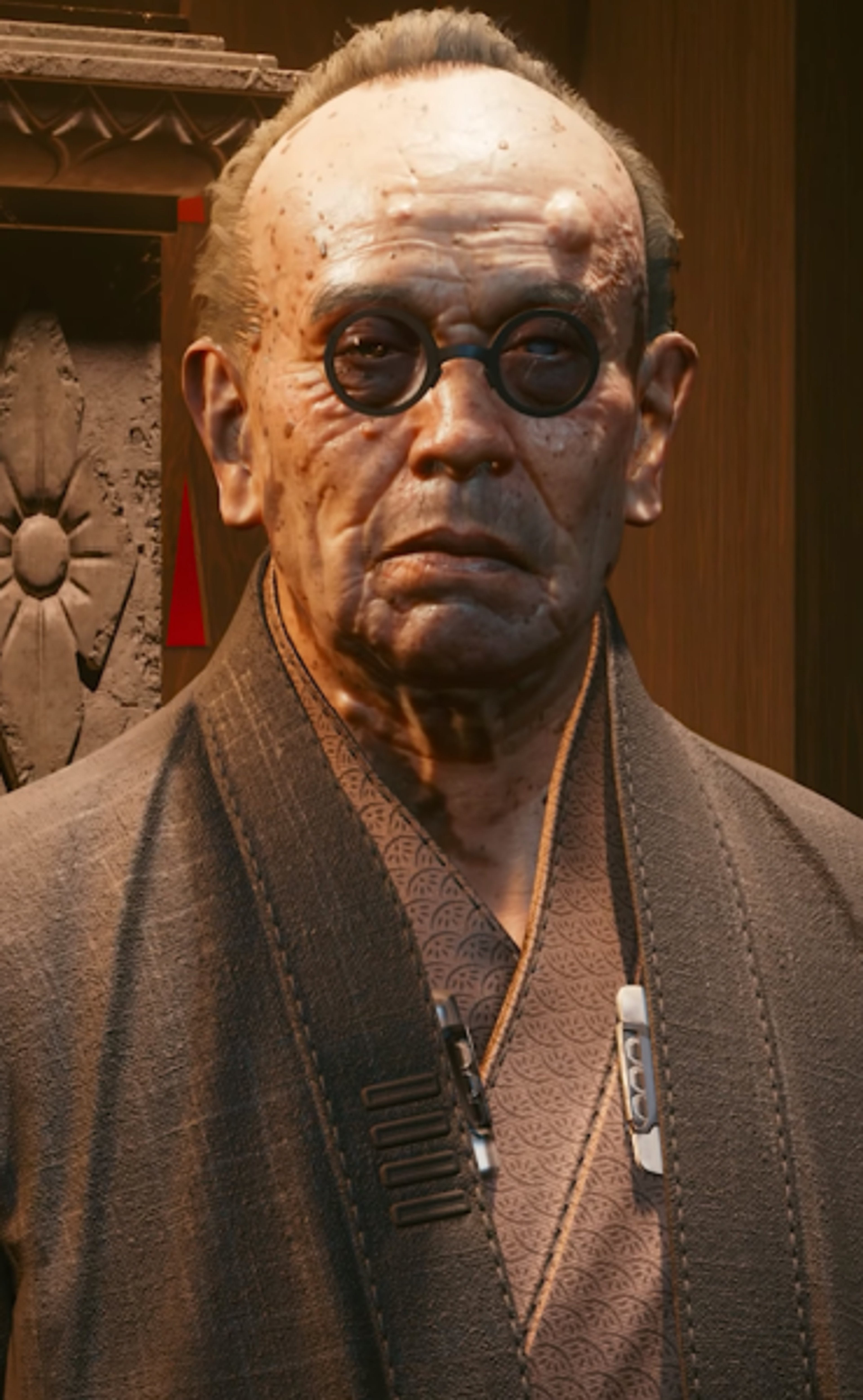 An elderly Asian man with a bald head, thick eyebrows, and round glasses, wearing a dark gray robe or kimono and having a stern expression.