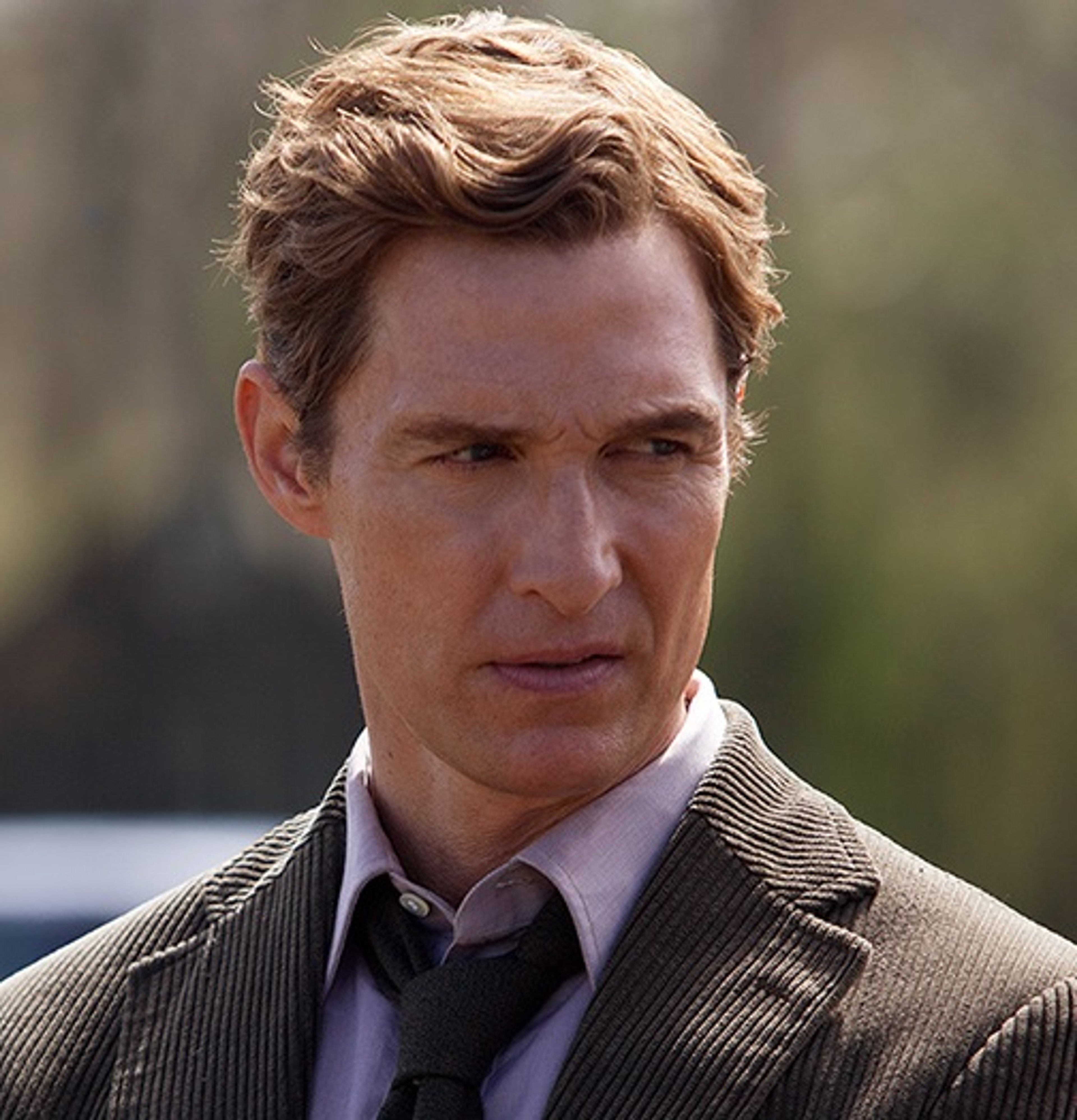 A middle-aged man in a suit and tie with a serious expression