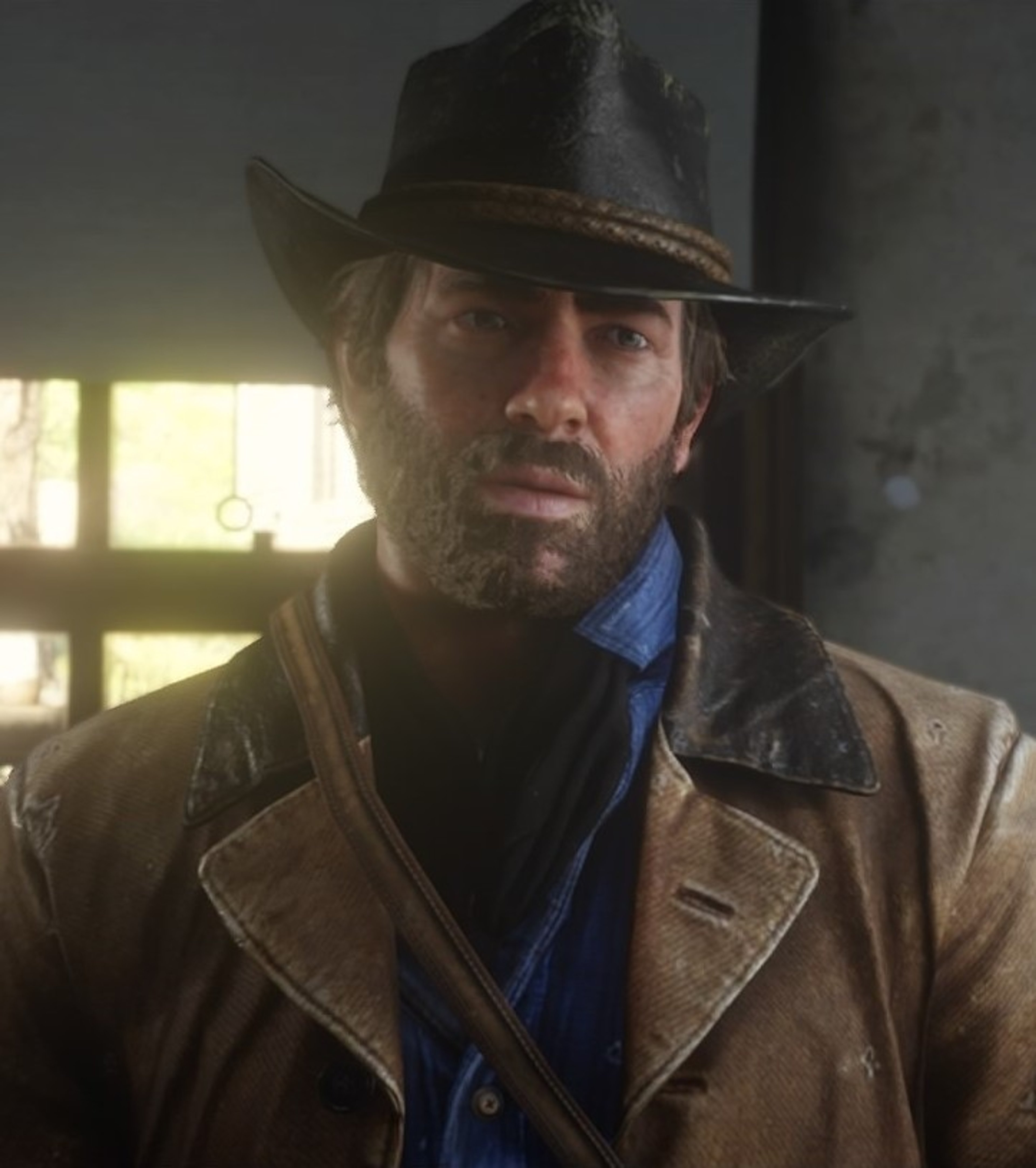 A rugged, bearded man in a cowboy hat and coat, with a serious expression on his face.