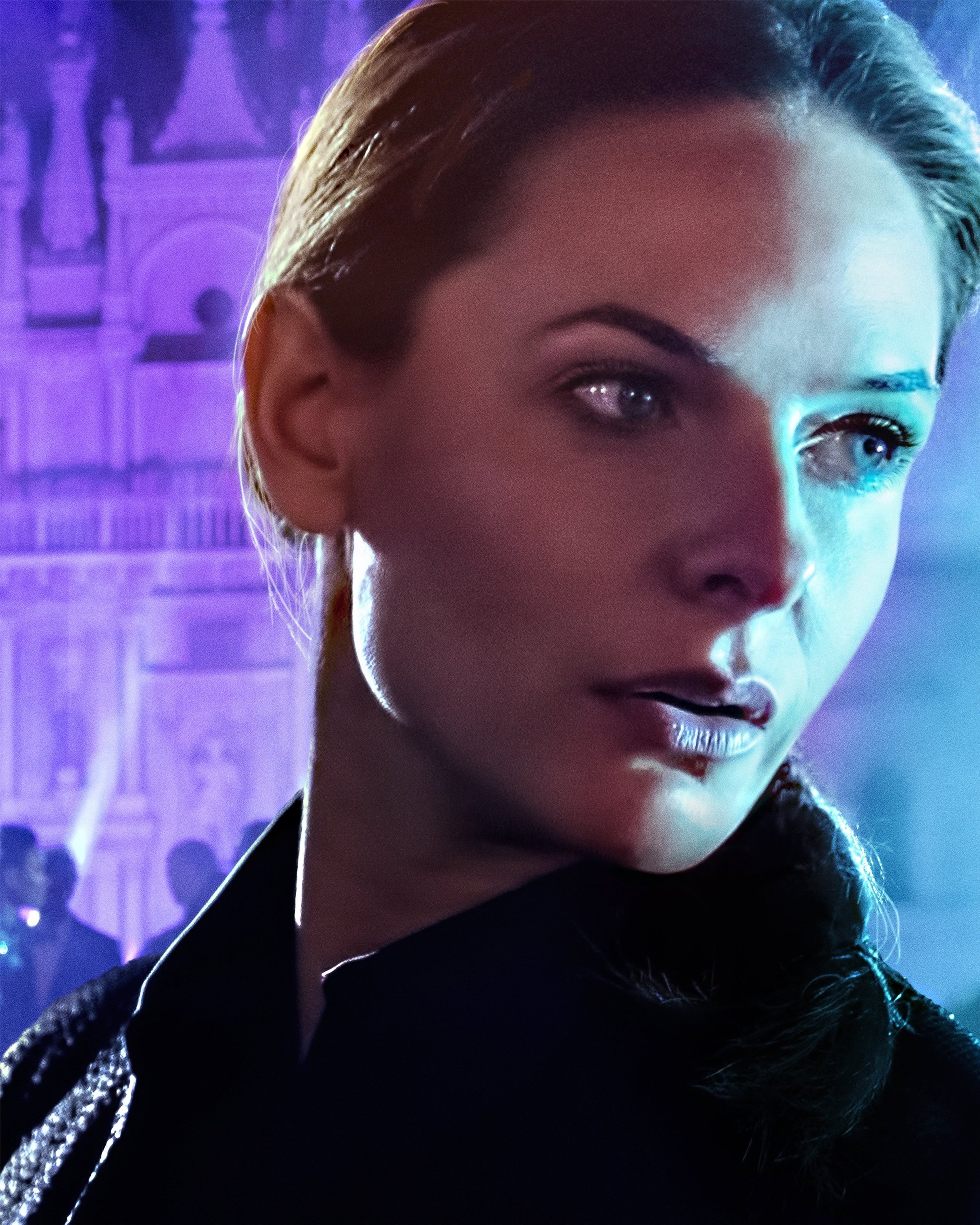 A close-up portrait of a serious-looking woman with blonde hair and blue eyes