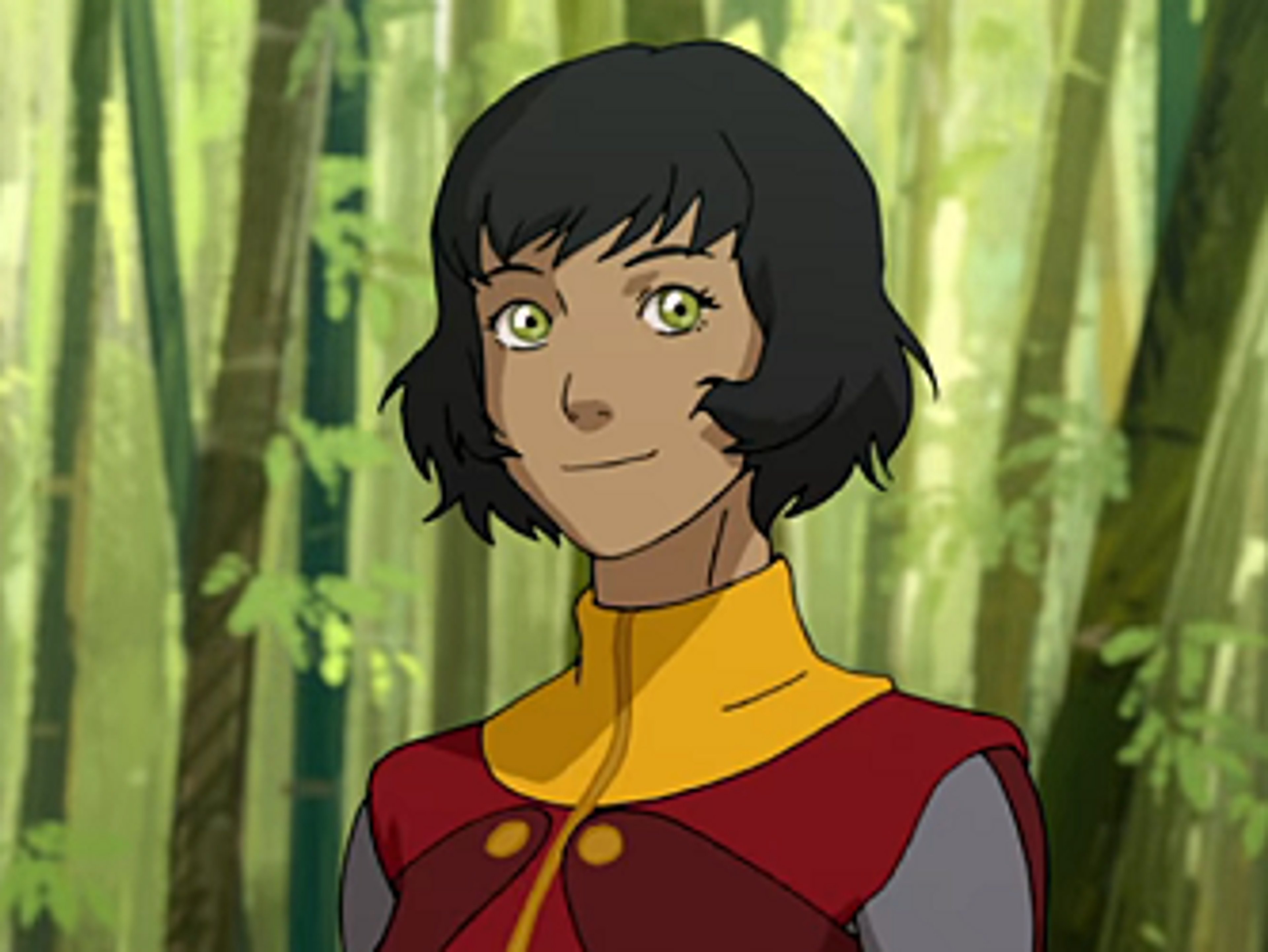 A young woman with short dark hair wearing an airbender uniform in a forest setting.