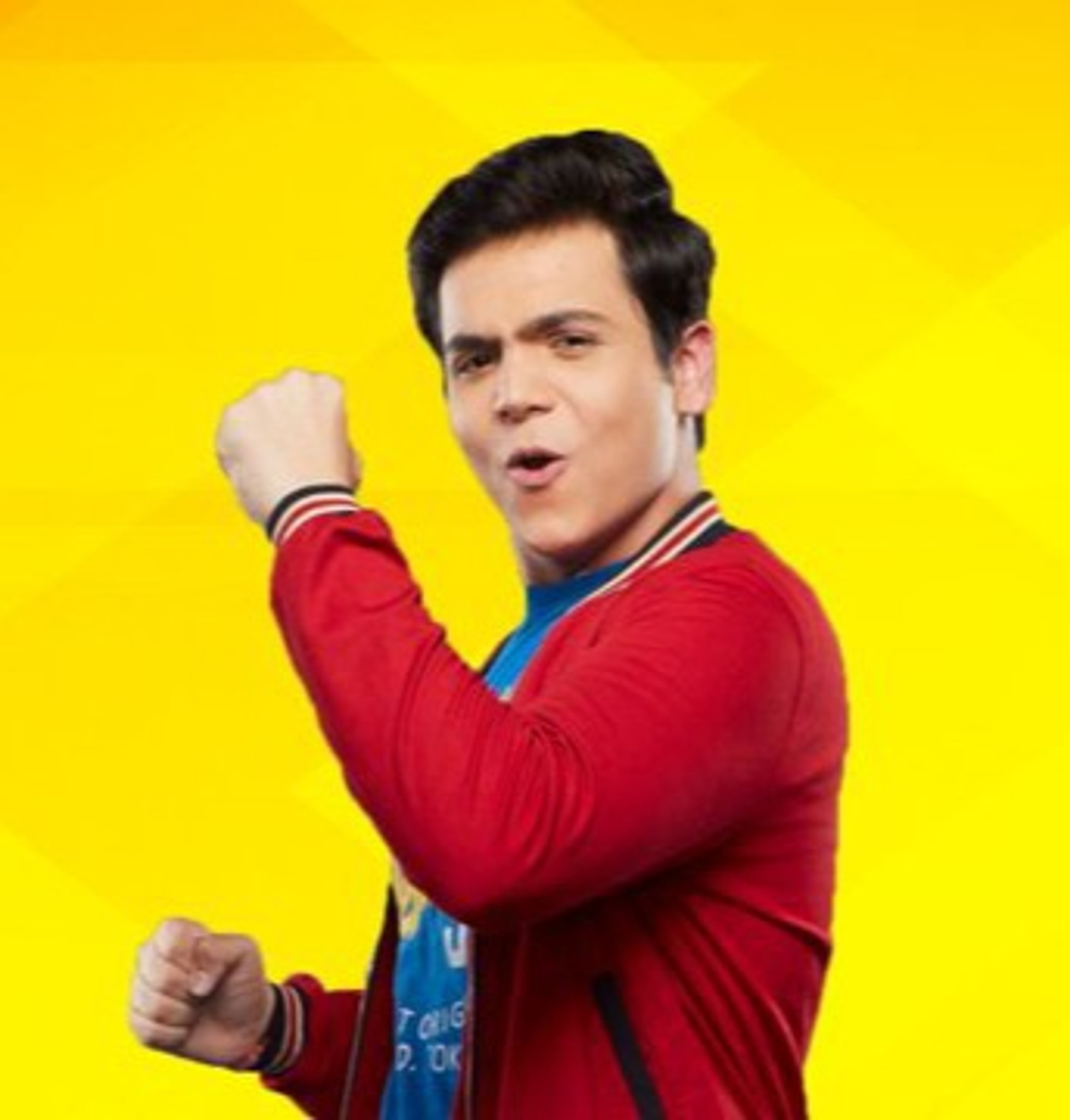 A man in a red shirt making a fist with a serious expression